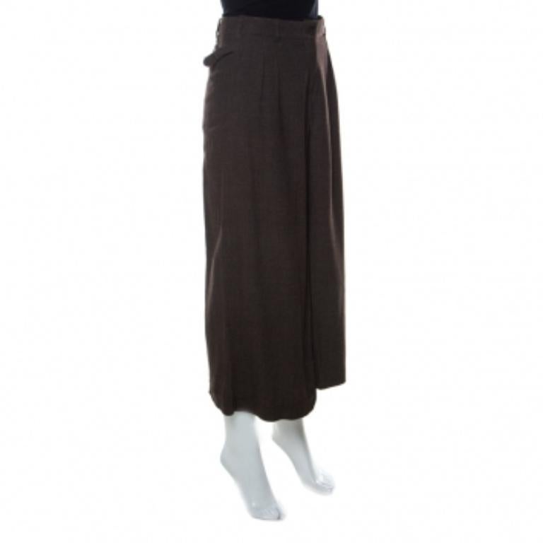 Questi pantaloni culottes di Kenzo sono molto eleganti e ti faranno sicuramente guadagnare molti complimenti. Sono realizzate in misto lana e presentano una tonalità marrone scuro. Sfoggiano una silhouette a pieghe con chiusura a bottoni e quattro