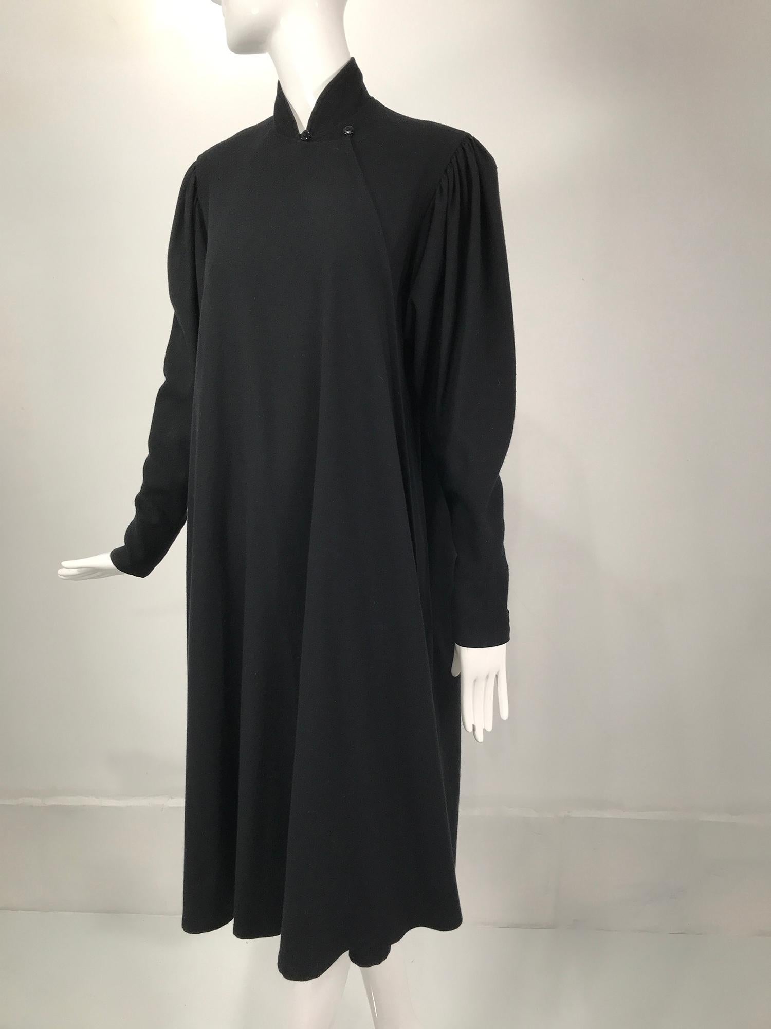 Kenzo double face black wool cheongsam style coat from the 1980s. Unusual coat with a high band collar that wraps in the front and closes with double loop and buttons ending there with the similarly to the cheongsam. The coat wraps and is open to