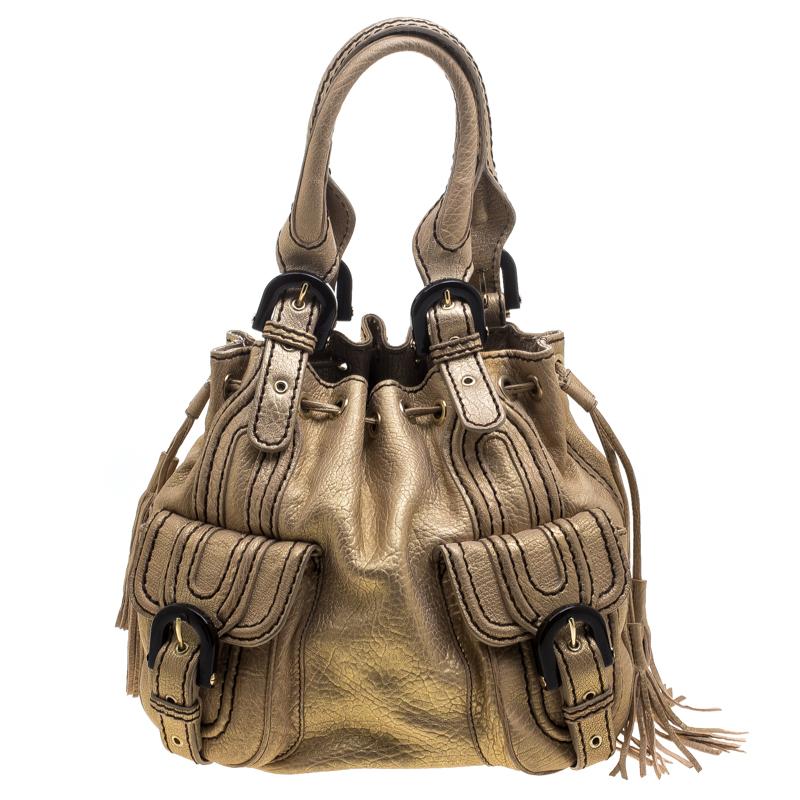 Kenzo's bucket bag will add a stylish element to your wardrobe. Crafted with golden leather, it has a soft structure with a double flap pocket placed both on the front and back and secured with buckles. The top has a drawstring closure detailed with