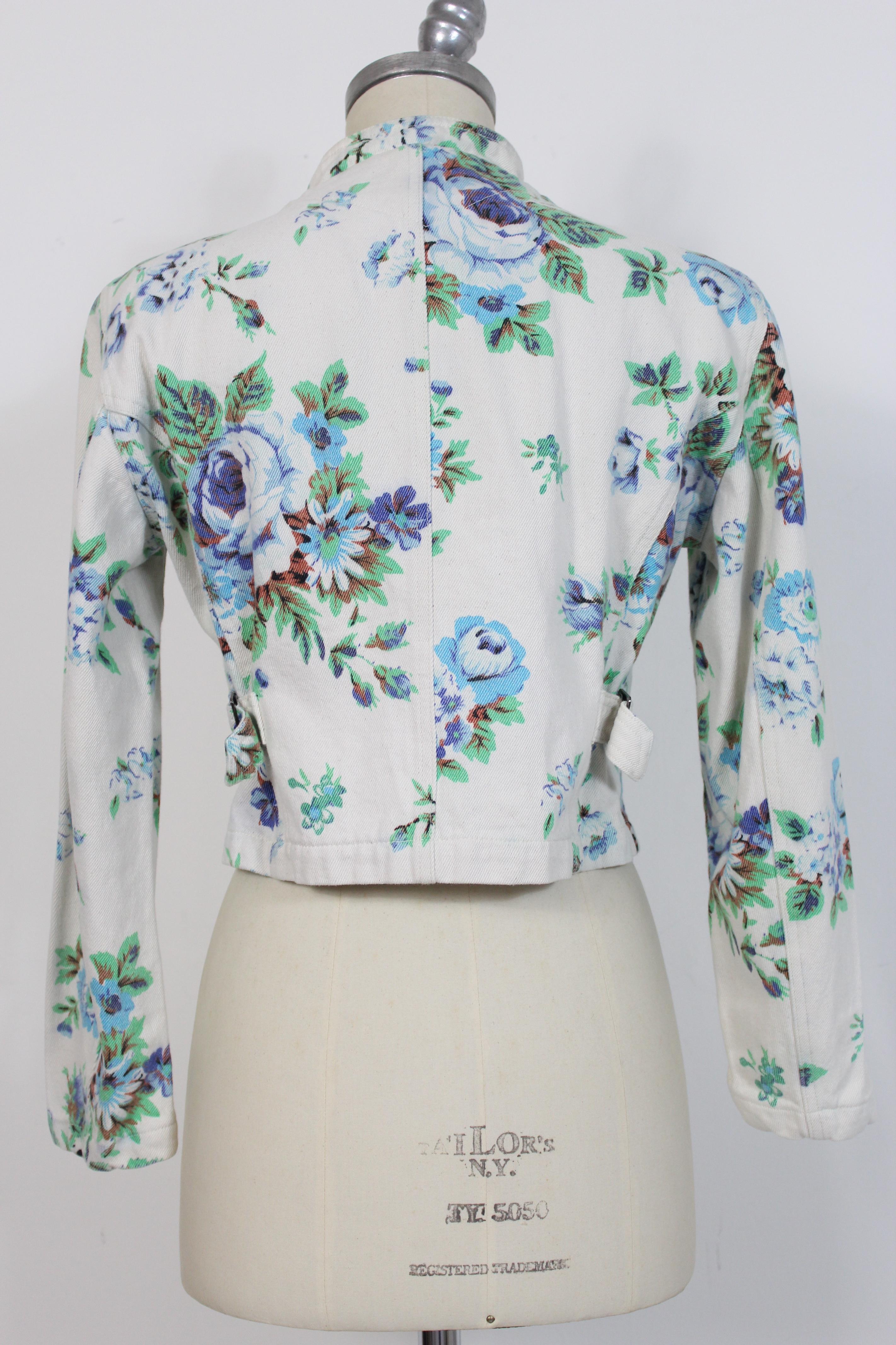 Kenzo Jeans vintage 80s women's jacket. Short denim jacket, blue and beige with floral designs. There are shoulder pads. 100% cotton. Made in France. Good vintage condition, with some stains that do not compromise the beauty of the garment.

Size: