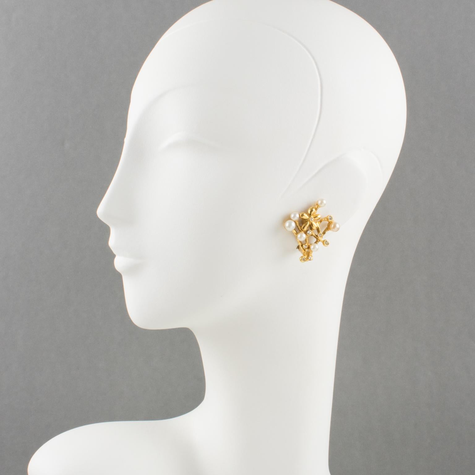 These romantic Kenzo Paris signed clip-on earrings feature a floral shape with gilt metal carved and see-thru in branches and flowers. The earrings are embellished with pearls-imitation and tiny crystal rhinestones. Hand-marked on the side,