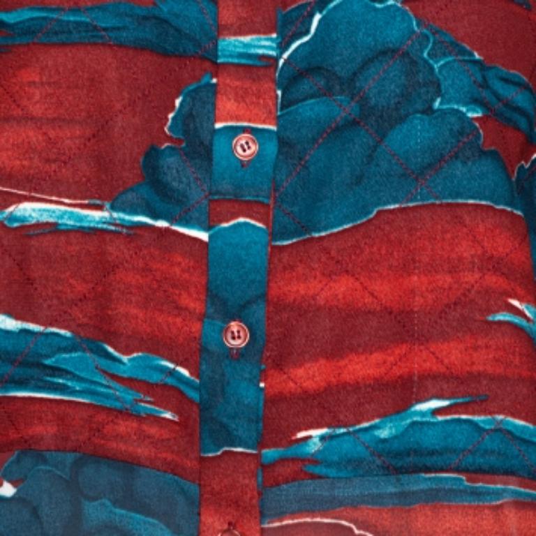 No matter what the mood for the occasion is, be sure to dazzle your way through in this Kenzo blouse. It is a brand known for its creative prints and this shirt has lovely cloud prints all over the maroon chiffon fabric. This blouse offers a