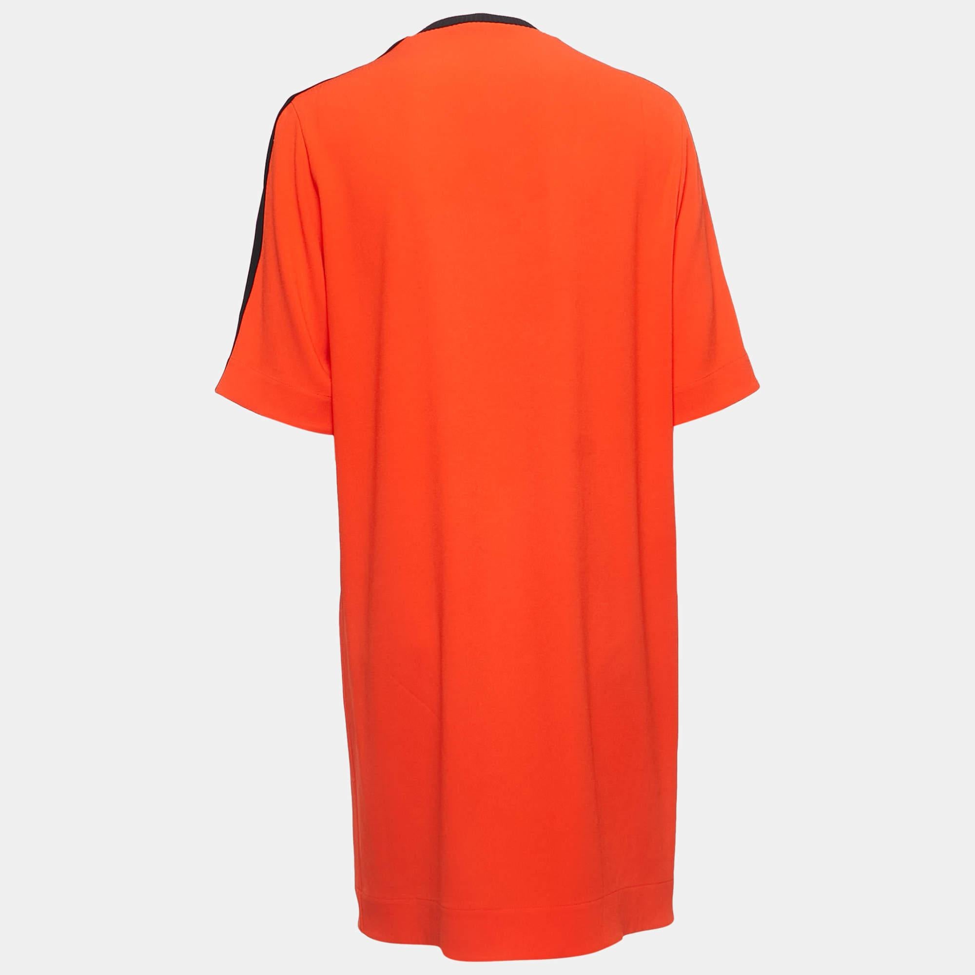 The Kenzo Odress is a vibrant, knee-length garment that combines comfort and style. It features a bold orange hue, a relaxed T-shirt silhouette, and a signature tiger motif, making it a chic and casual fashion statement.