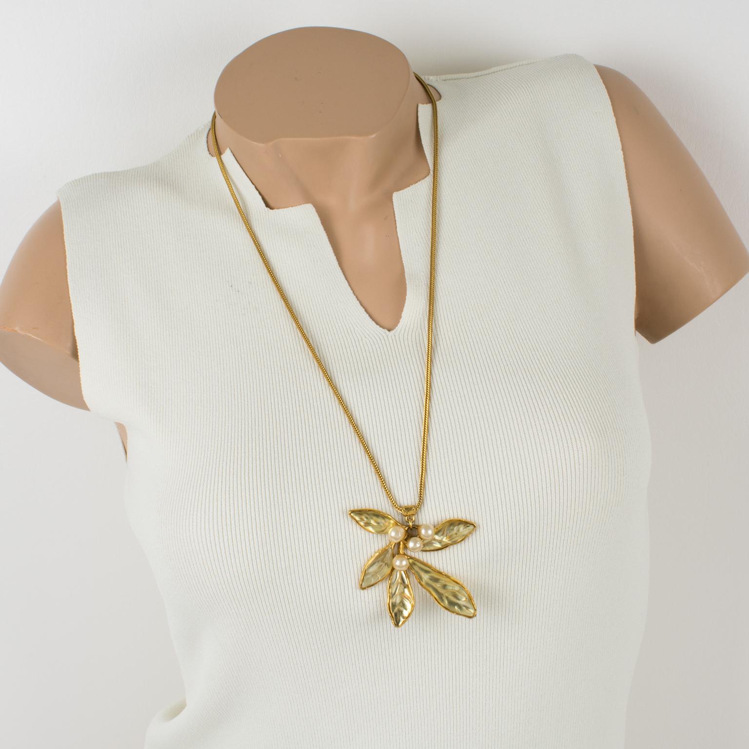 Elegant Kenzo Paris floral long pendant necklace. Gilt metal all carved and textured pendant featuring mistletoe flowers and leaves. Leaves are yellow champagne carved resin and flowers are pearl-like beads. Long serpentine gilt metal chain with