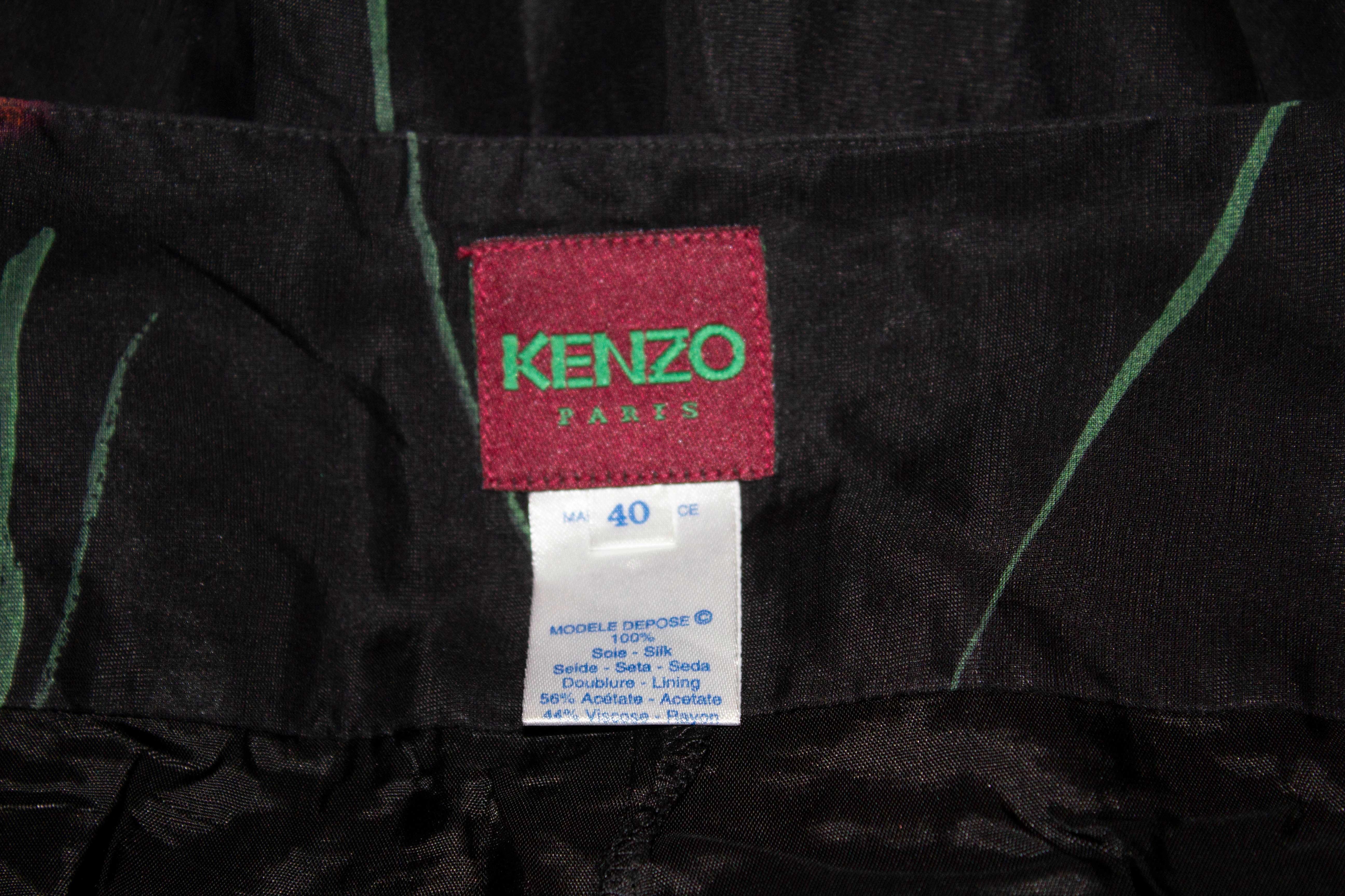 A pretty silk skirt by Kenzo Paris. The skirt has a black background with a floral print. It has a 3'' deep waist band  and flares with a 4'' frill at the hem.  Size 40 Measurements : waist 29'', length 36''