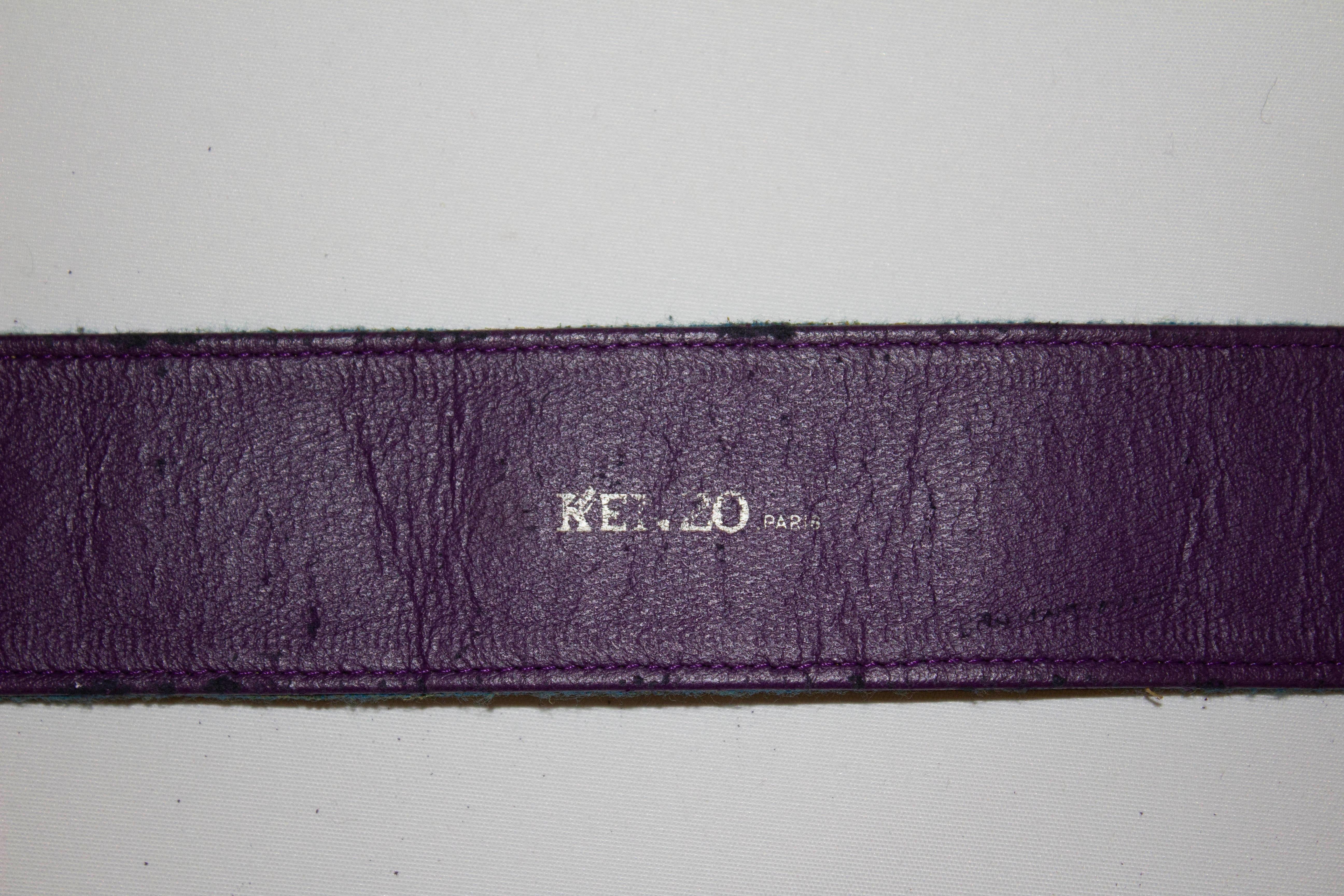  A great vintage belt for Spring by Kenzo Paris. The belt has a turquoise background with floral detail and a purple leather lining on the back. 
Measurements: height 2'', length 29''