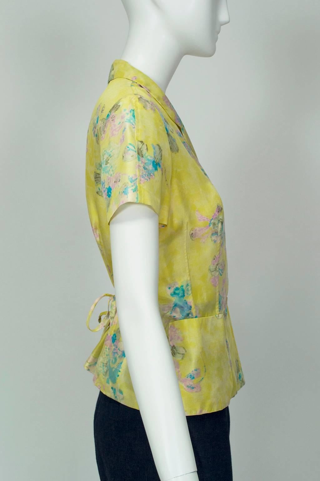 A blouse that delivers a breath of spring the moment it is put on, this button front shirt features rear waist ties for a peplum silhouette and adjustable waistline. The delicate yellow, purple and turquoise watercolor iris print is the perfect