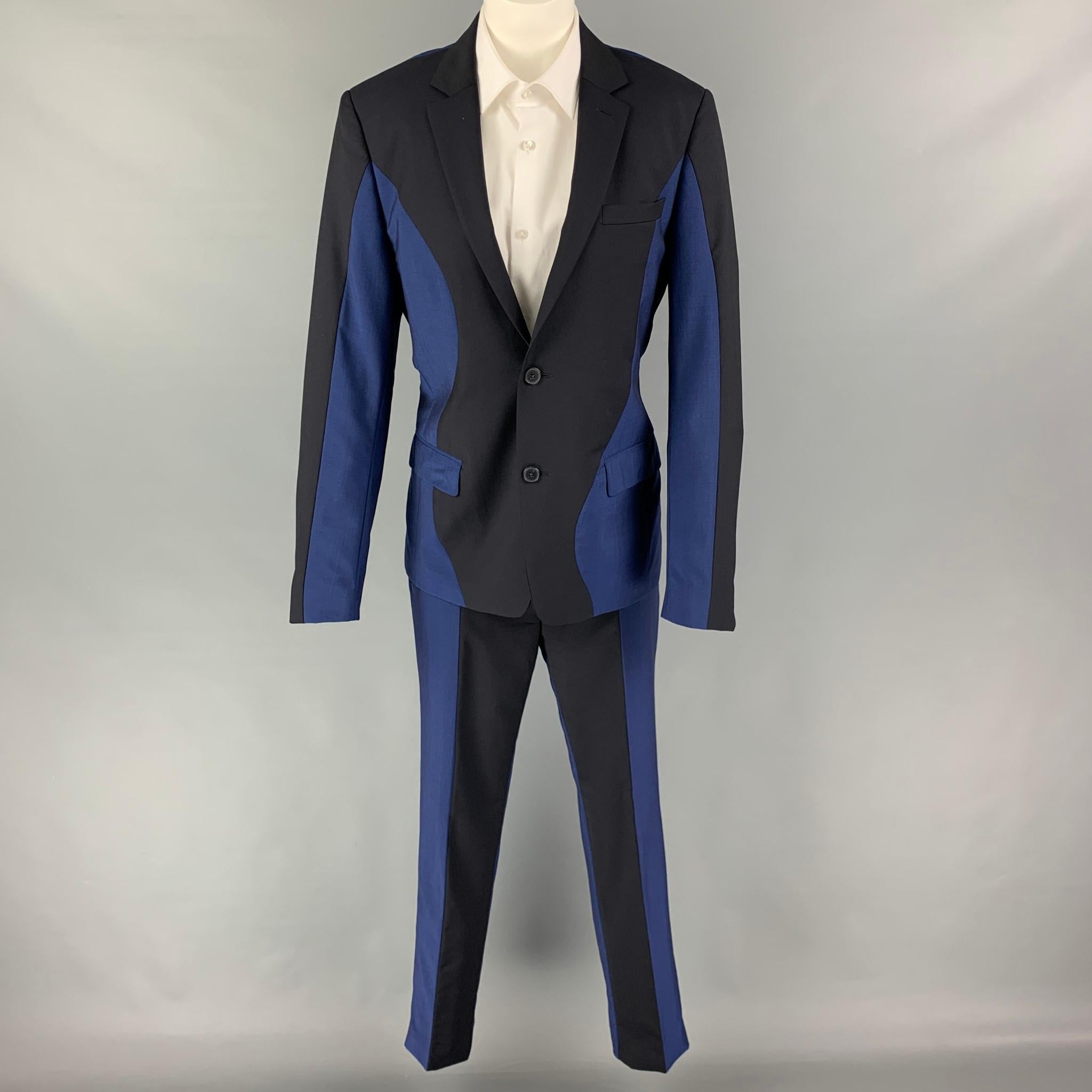 Le costume KENZO est en laine et mohair marine et bleu avec une doublure complète et comprend un manteau de sport à un seul boutonnage avec un revers à encoche et un pantalon assorti à devant plat.

Excellent état d'origine.
Marqué : 48

Mesures