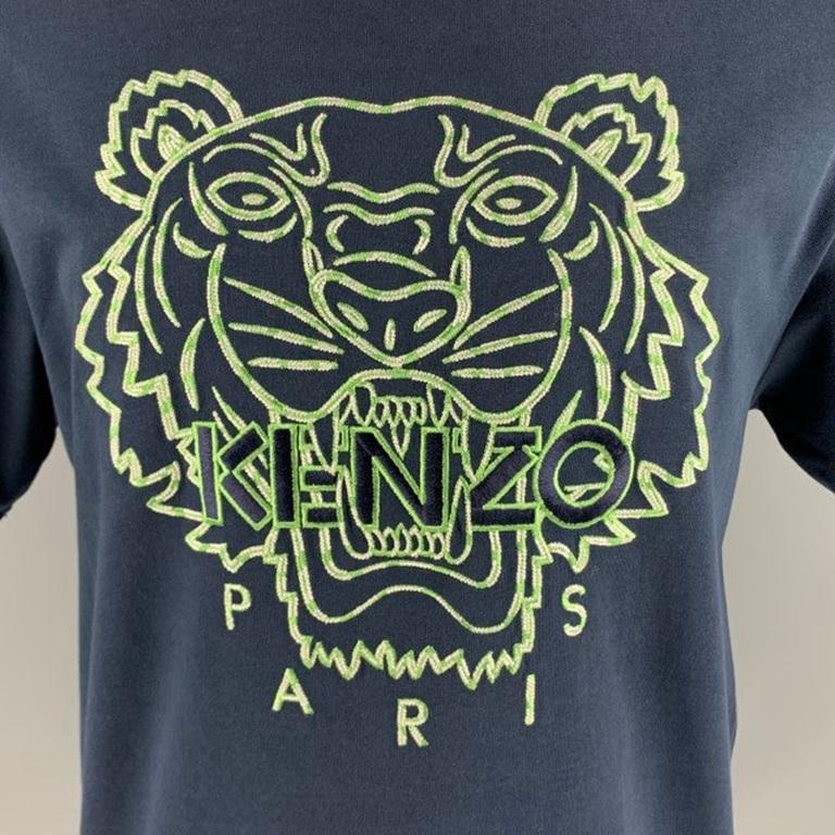 KENZO t-shirt
in a navy cotton fabric featuring an embroidered green and white tiger design with with Kenzo logo, and crew neck.Very Good Pre-Owned Condition. Minor marks on upper back. Fabric care tags removed. 

Marked:   M 

Measurements: 
