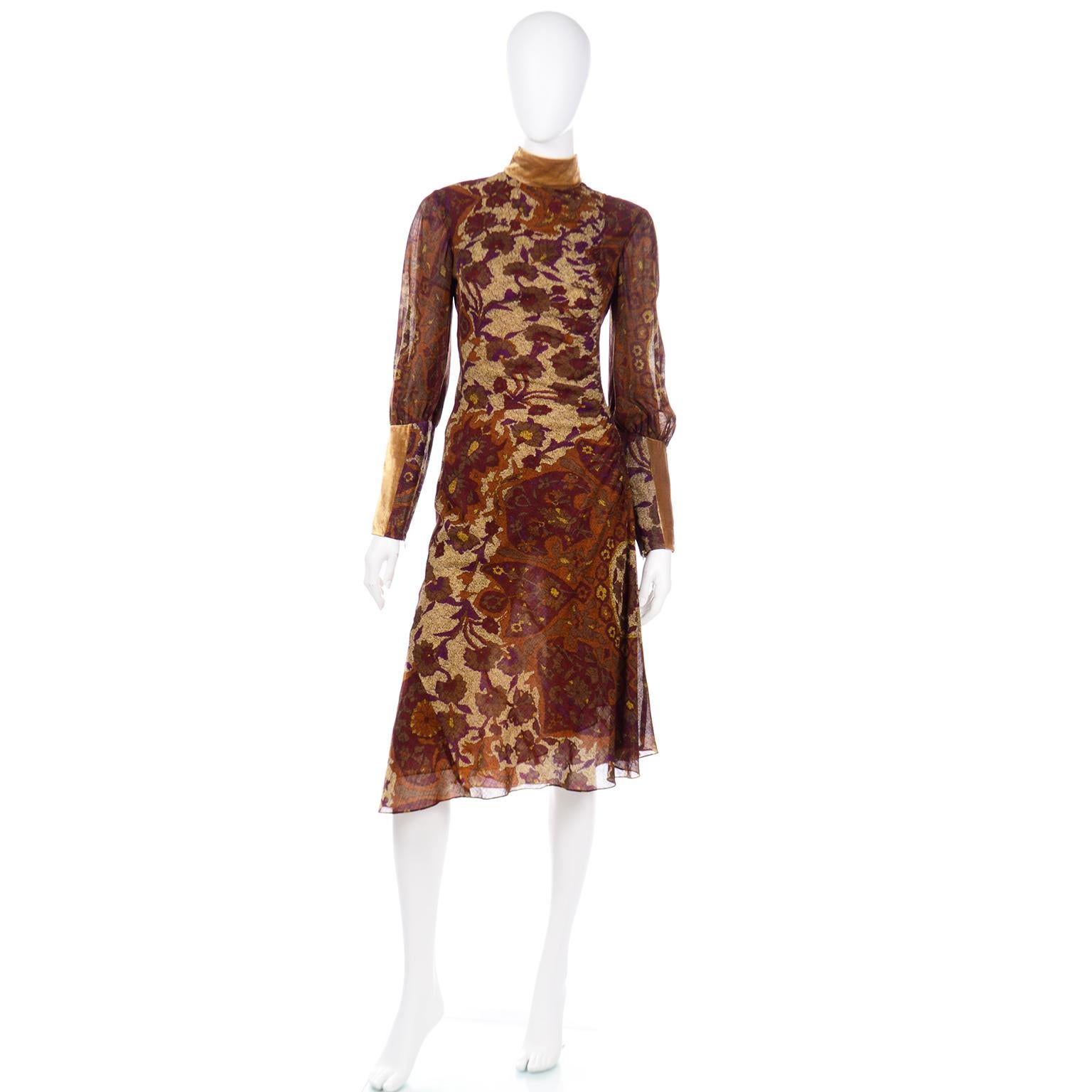 This gorgeous vintage Kenzo dress is in an abstract floral print in rich shades of plum, soft gold, copper and brown with gold velvet trim at the collar and cuffs. The semi sheer fabric is lined in gold organza. One side has ruching and the dress