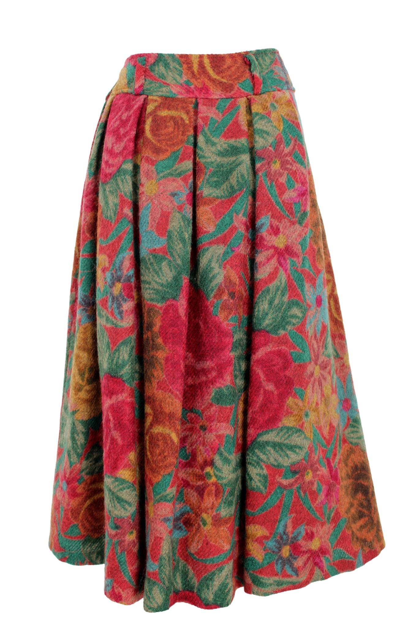 Cette jupe ballon vintage 80s de Kenzo est un ajout unique à toute garde-robe. Fabriquée en laine de haute qualité, cette jupe présente un motif floral vibrant dans des tons de rouge et de vert. La silhouette ballon ajoute une touche ludique à la