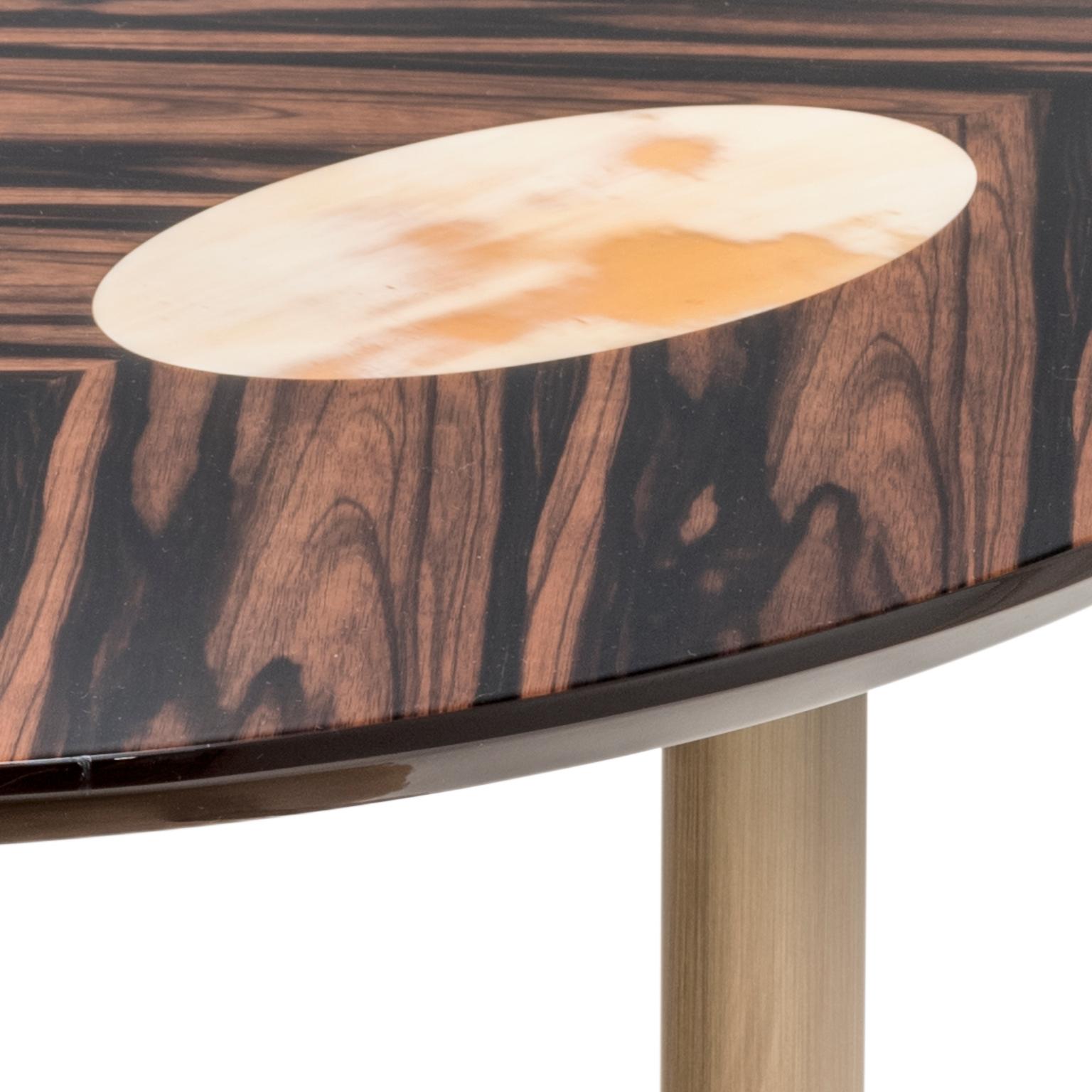 Der Keplero Beistelltisch verspricht, sowohl elegant als auch praktisch zu sein, um alle wichtigen Dinge in Reichweite des Sofas aufzubewahren, und zeigt dabei Handwerkskunst auf höchstem Niveau. Die ovale Tischplatte aus Makassar-Ebenholzfurnier