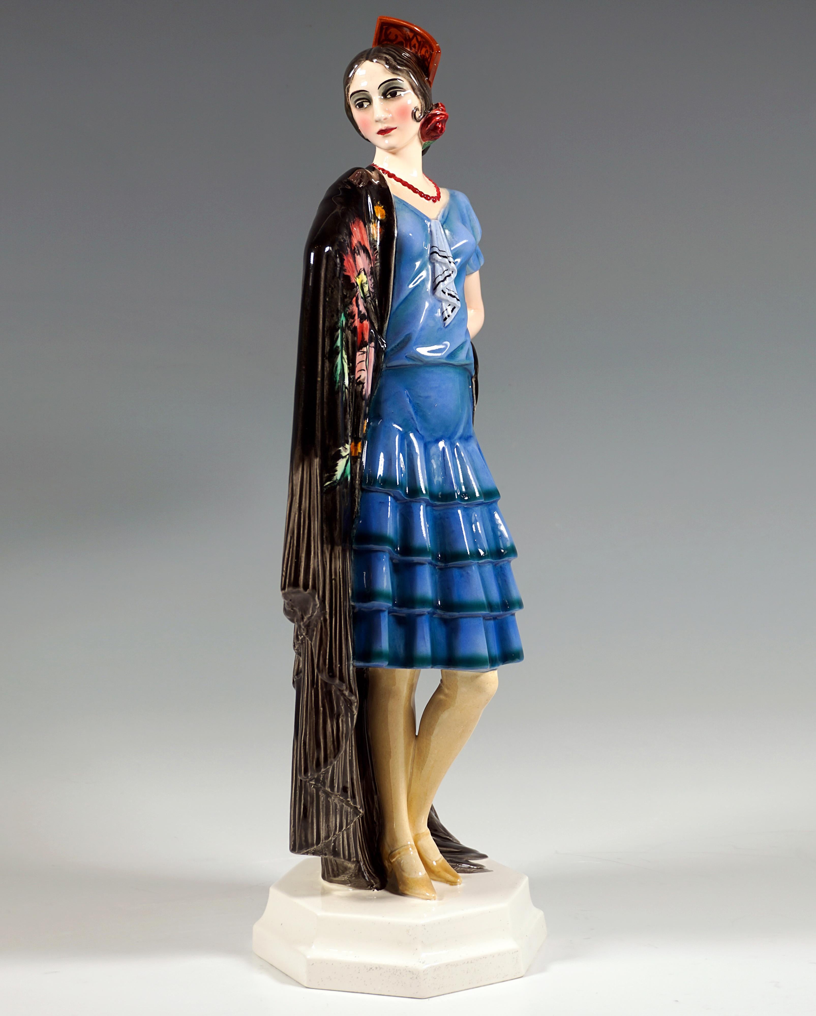 Rarísima figura vienesa de cerámica Art Déco:
Joven y guapa dama vestida con un traje azul de blusa de manga corta y falda de volantes, con el pelo oscuro recogido y recogido al estilo de las españolas, con un collar de perlas rojas y una rosa como