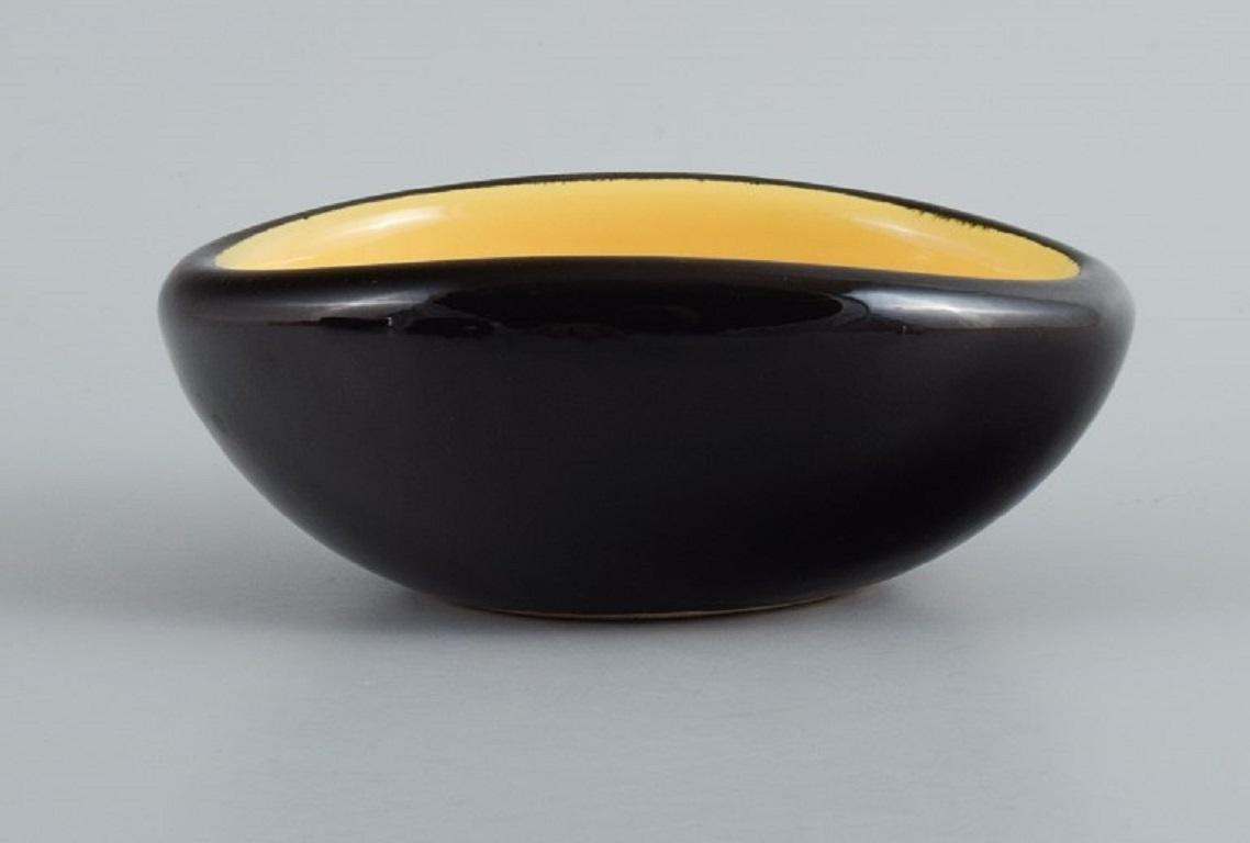 French Keramos, Sèvres, France. 3 unique ceramic bowls glazed in yellow and black.