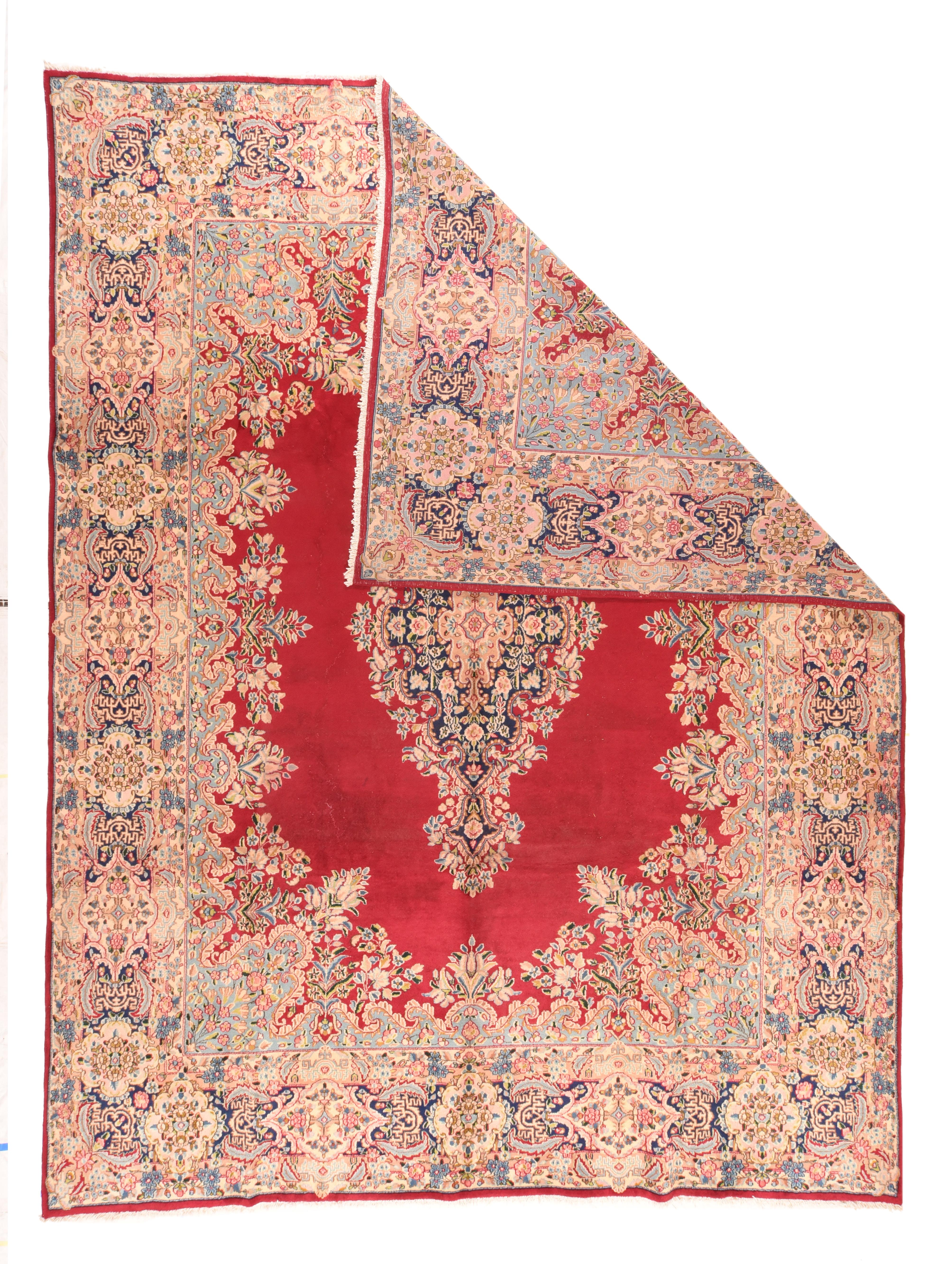 The crimson open field is edged and encroached by a lacy floral surround, while the vertically elongated  near black pendanted medallion floats freely. Royal blue border with cartouches and  octofoils. Wide palette including: sand, straw, pistachio,