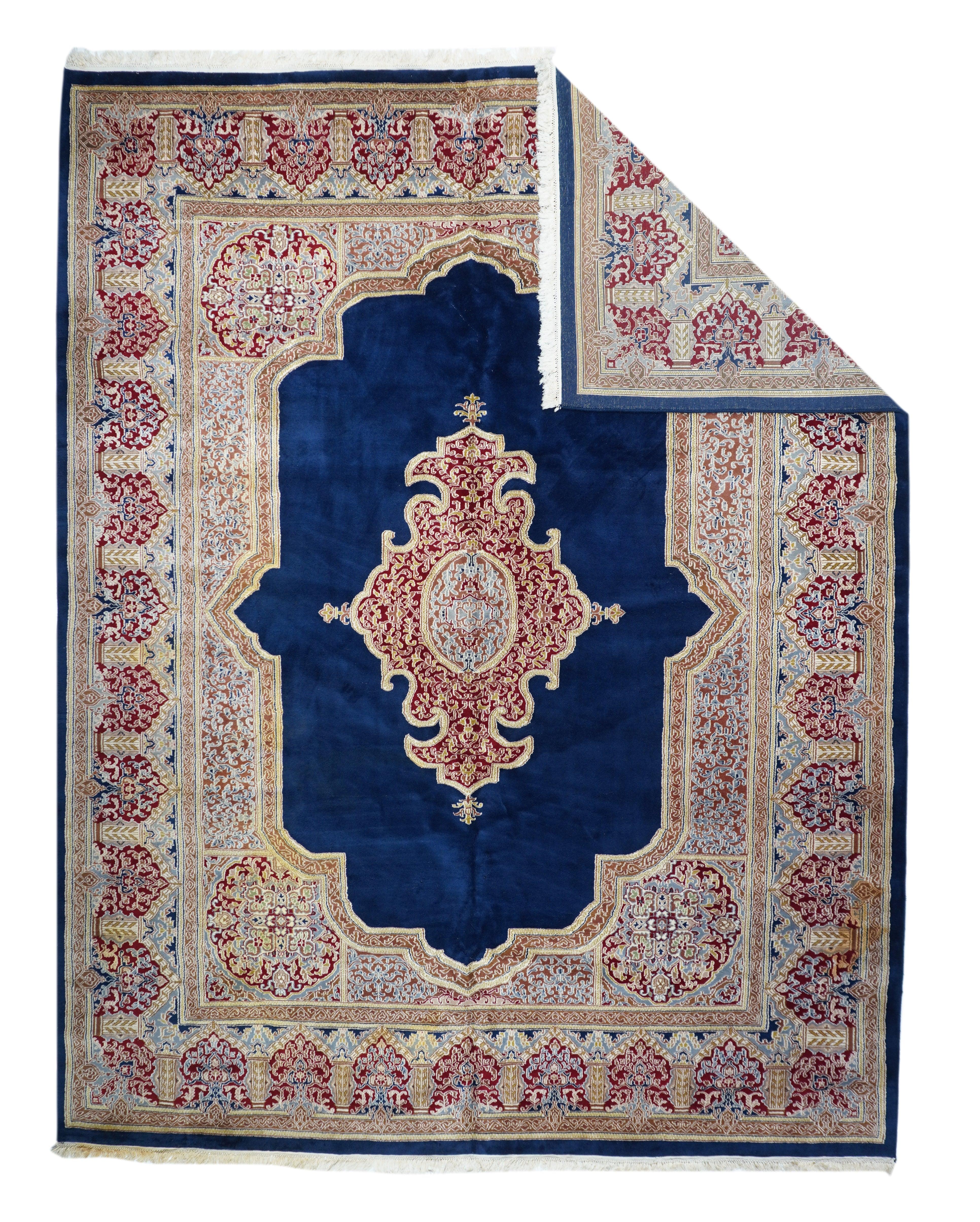 Tappeto Kerman 9'10'' x 12'7''. Il sottocampo aperto di colore blu reale intenso di questo pezzo con copertina a libro mostra il complesso medaglione con contorno di cinghie e il sottomedaglione ellittico rosso ruggine. Il campo rosso conforme forma