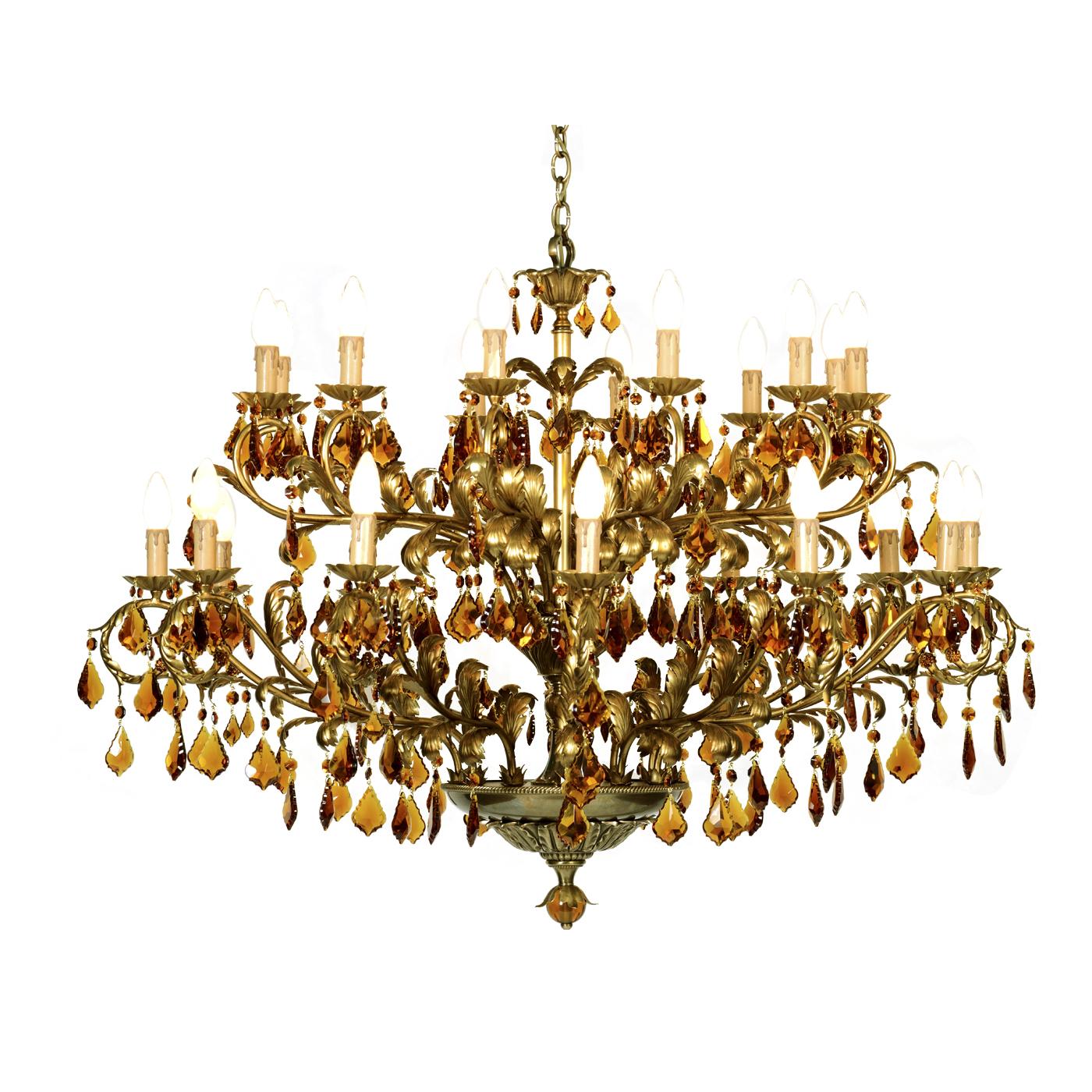 This superb chandelier features 24 sinuous arms in bronze with an aged brass finish and details in iron finished with gold leaf. Each arm supports a light and is adorned with pendants in crystal with a delicate amber color. This piece will make a