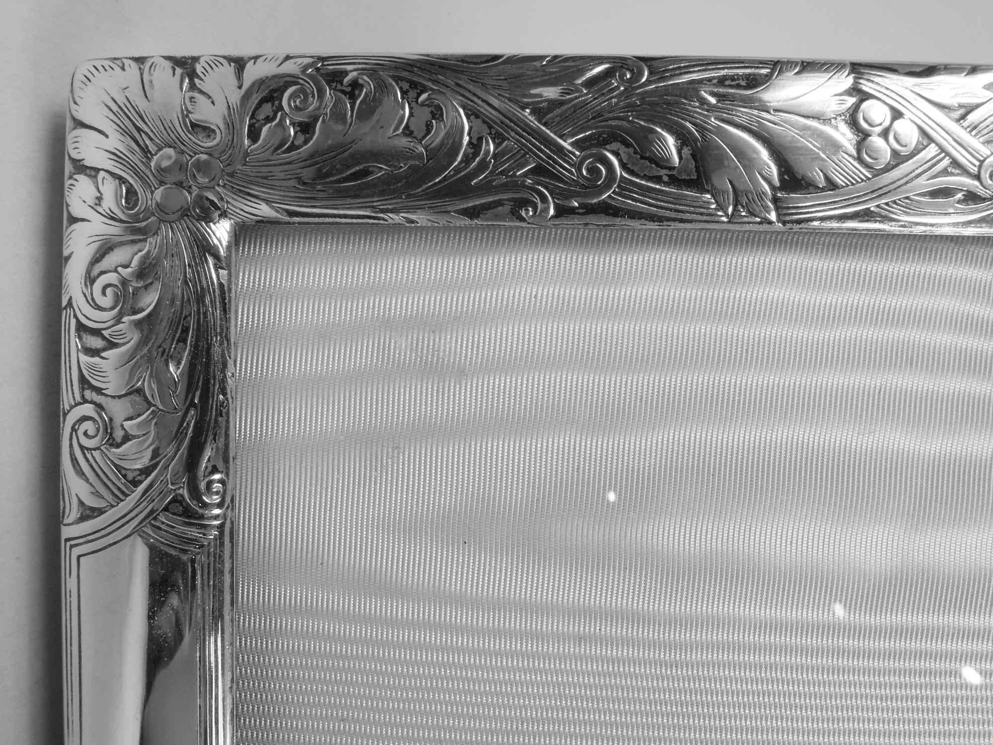 Edwardian Art Nouveau sterling silver picture frame. Made by William B. Kerr in Newark, ca 1910. Rectangular window in surround with acid-etched ornament: Leaves and berries entwined with double scrolling bands. Rectangular cartouche (vacant). With