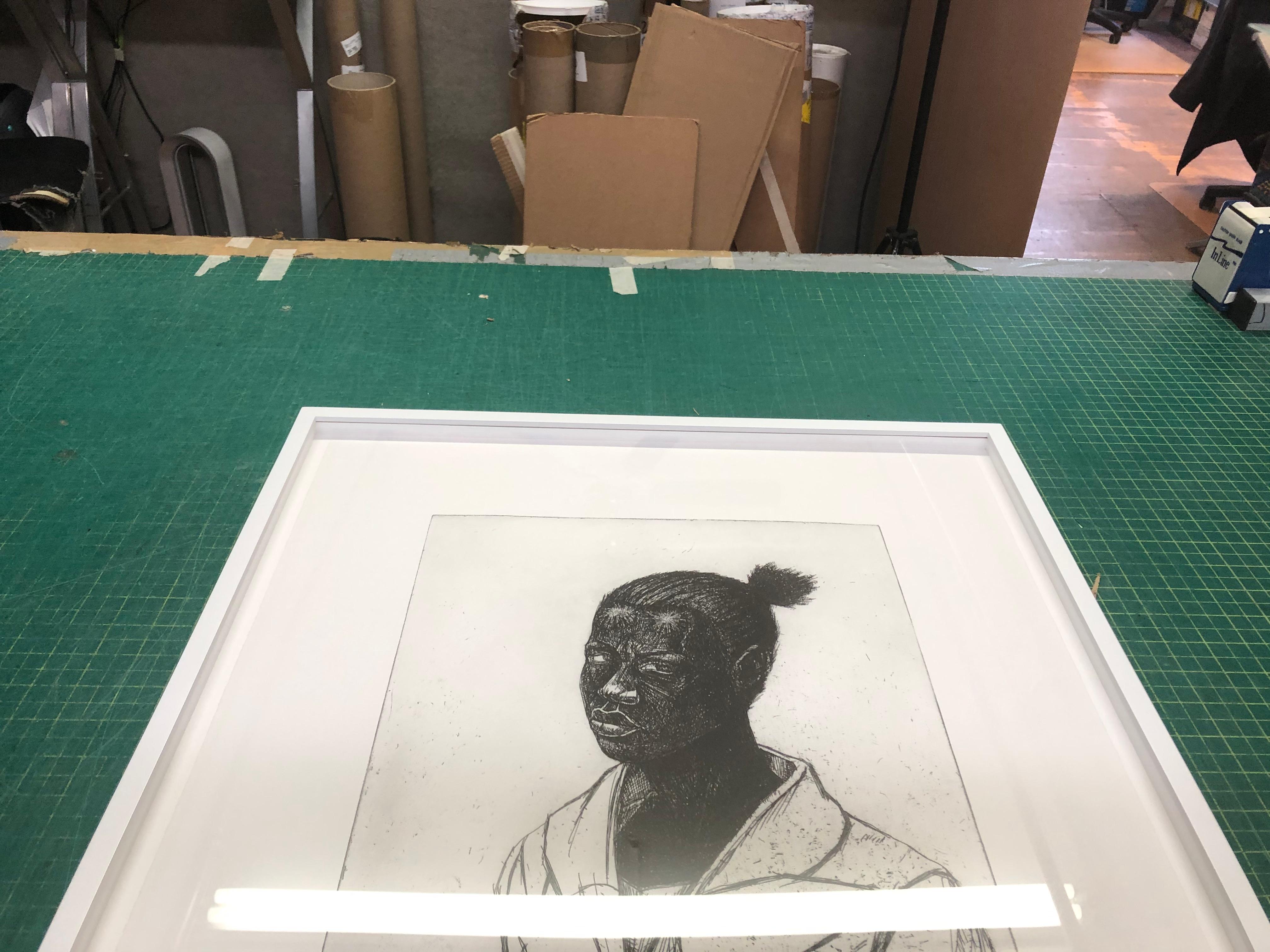 The etching Woman by Kerry James Marshall, published by Paulson Fontaine Press in Berkeley, California, is a limited edition work, signed and numbered 30/50 by the artist. Presented in a white wooden frame with UV-filtering Plexiglass, this piece