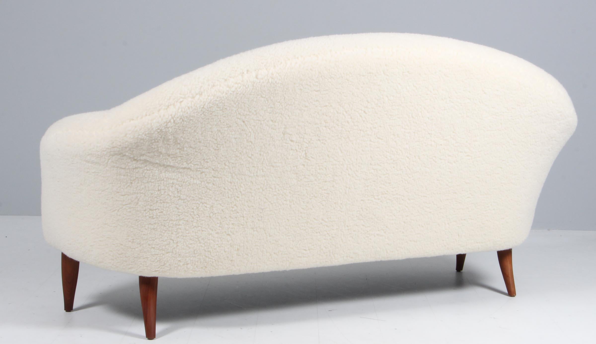 Kerstin Horlin Holmquist is a Swedish designer. This sofa was made for Nordiska Kompaniet in the 1950's. This was part of her Paradise design. This is the larger version. It features a soft curved line of the back and tapered and curved teak legs.