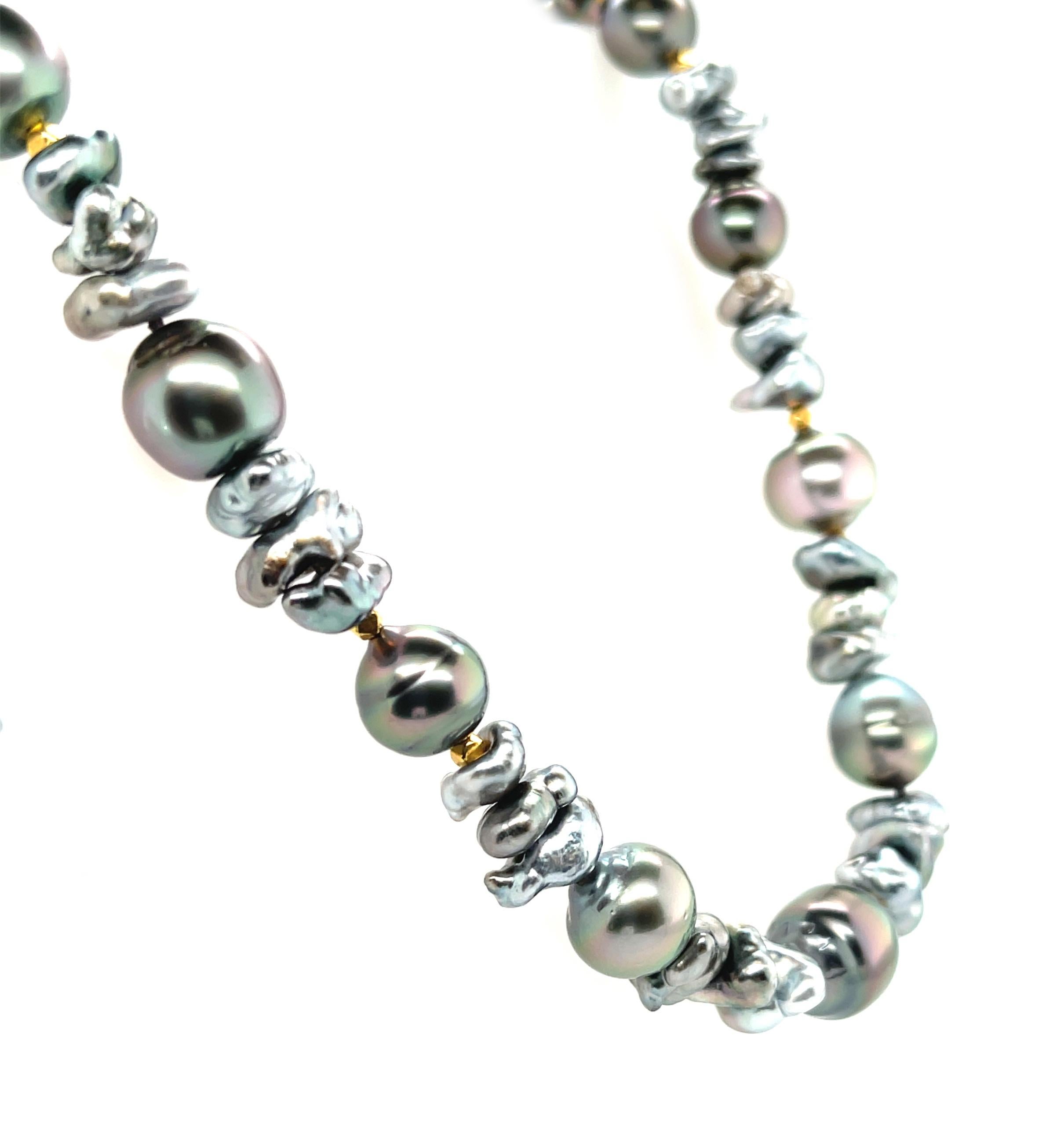 This gorgeous necklace features a beautiful collection of large, silvery black baroque pearls alternating with triple clusters of silver, gray and blue keshi pearls! Keshi pearls are formed naturally in mollusks, and their freeform shapes and