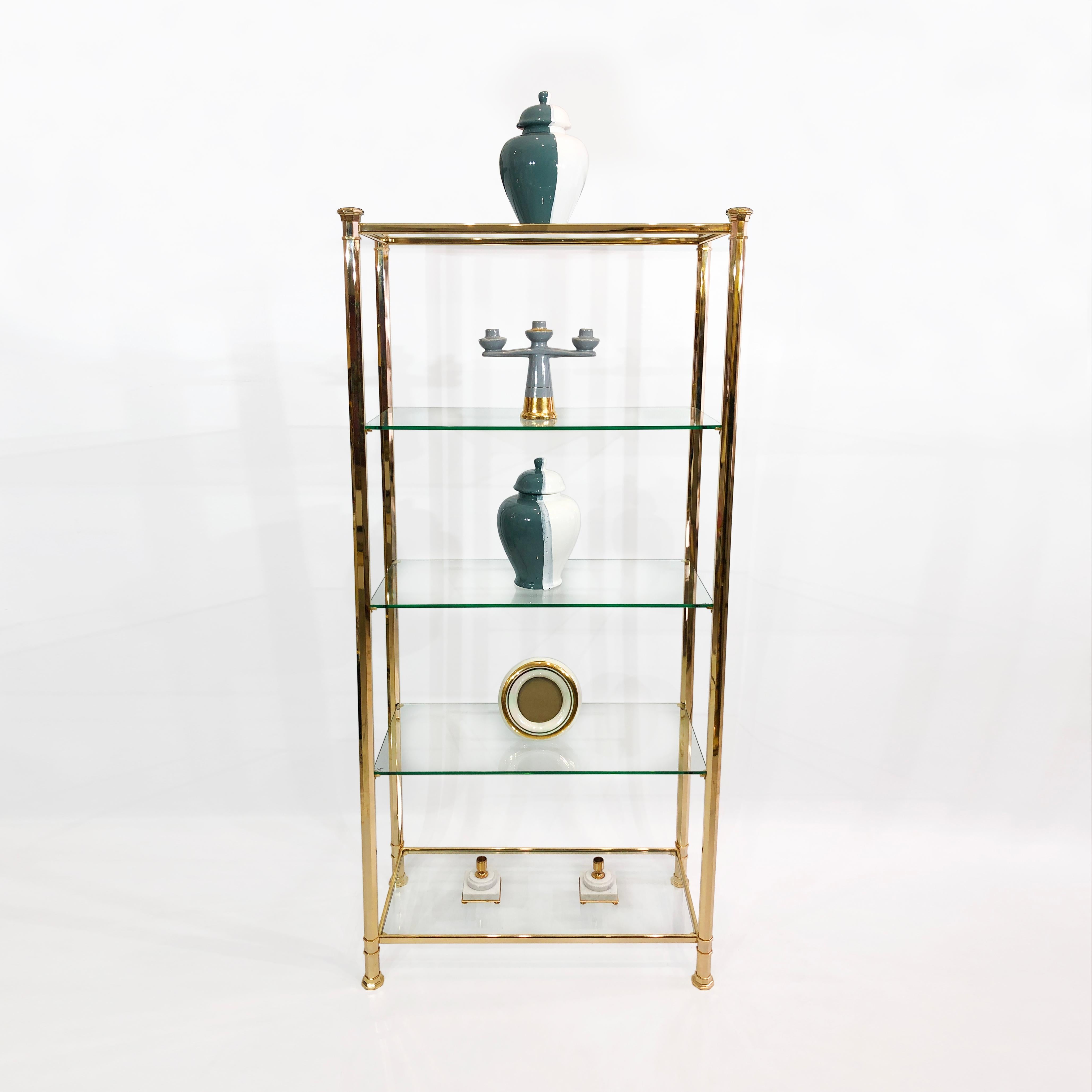 brass and glass shelving unit