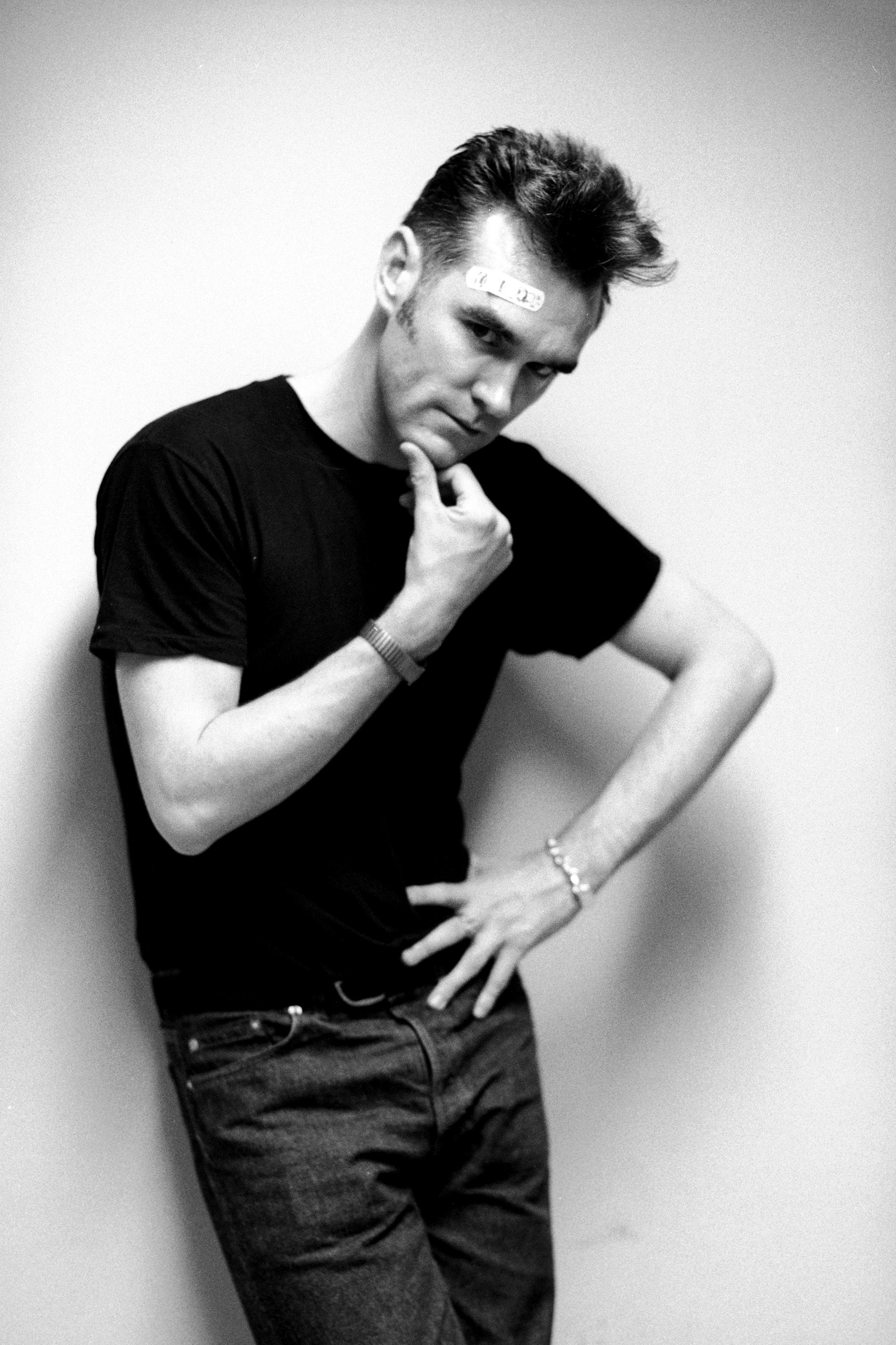 Signierter Silbergelatine-Druck in limitierter Auflage von Morrissey, dem ehemaligen Frontmann der Rockband The Smiths, mit einem Pflaster auf der Stirn, 5. September 1991.

Dieser Morrissey-Druck von Kevin Cummins ist in den folgenden Größen