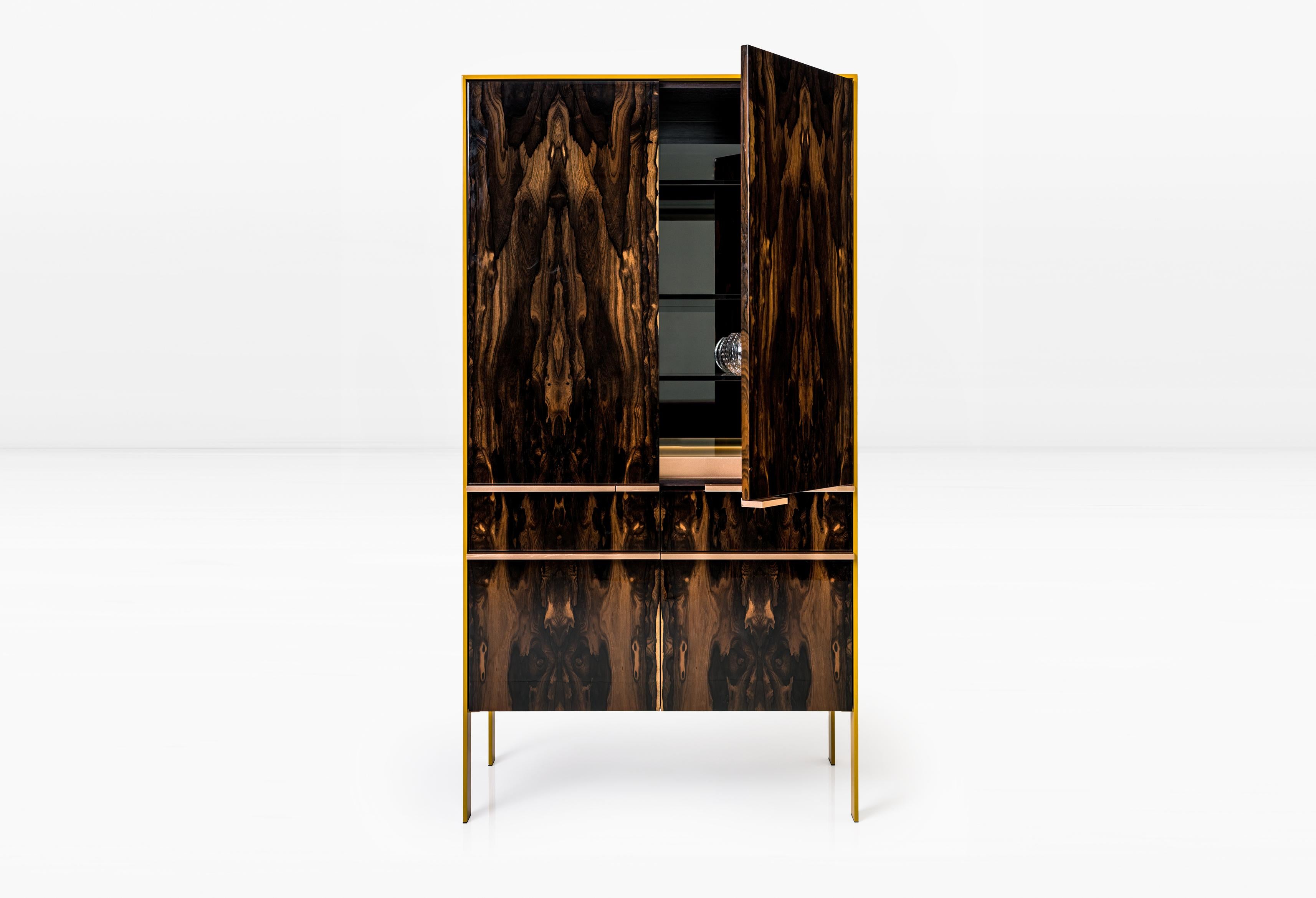 Lacquered aluminum skin encases the Johansson Bar Cabinet constructed of wood veneer exteriors & solid wood interiors and finished on all sides. The cabinet interior features glass shelves, back mirror, and illuminated lower glass lightbox.