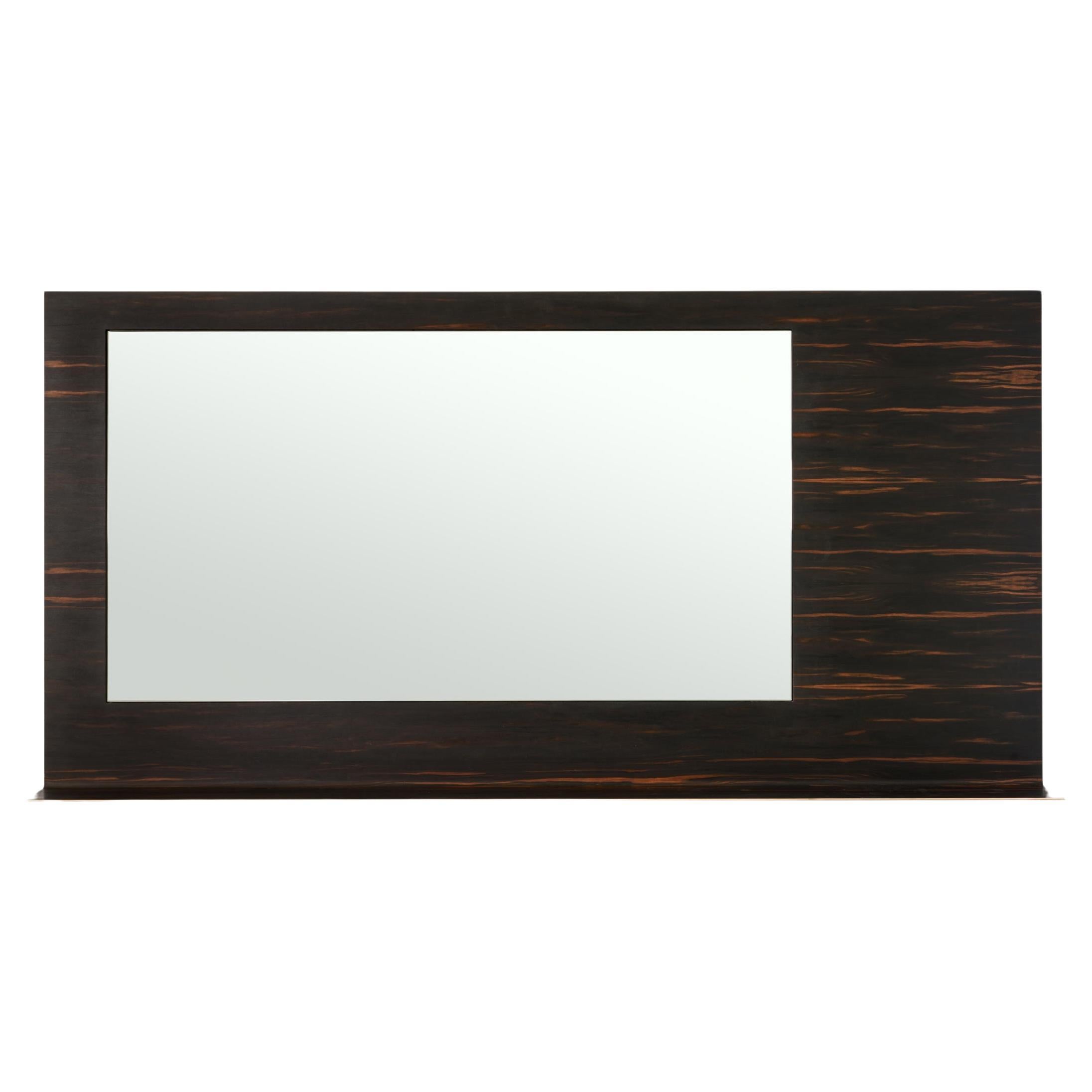 A sheet of Solid Bronze veneered in African Ebony surrounds a recessed mirror, folding itself out into a shelf for display.

This is a natural product that may have slight imperfections. This is the beauty of the product and makes it unique from