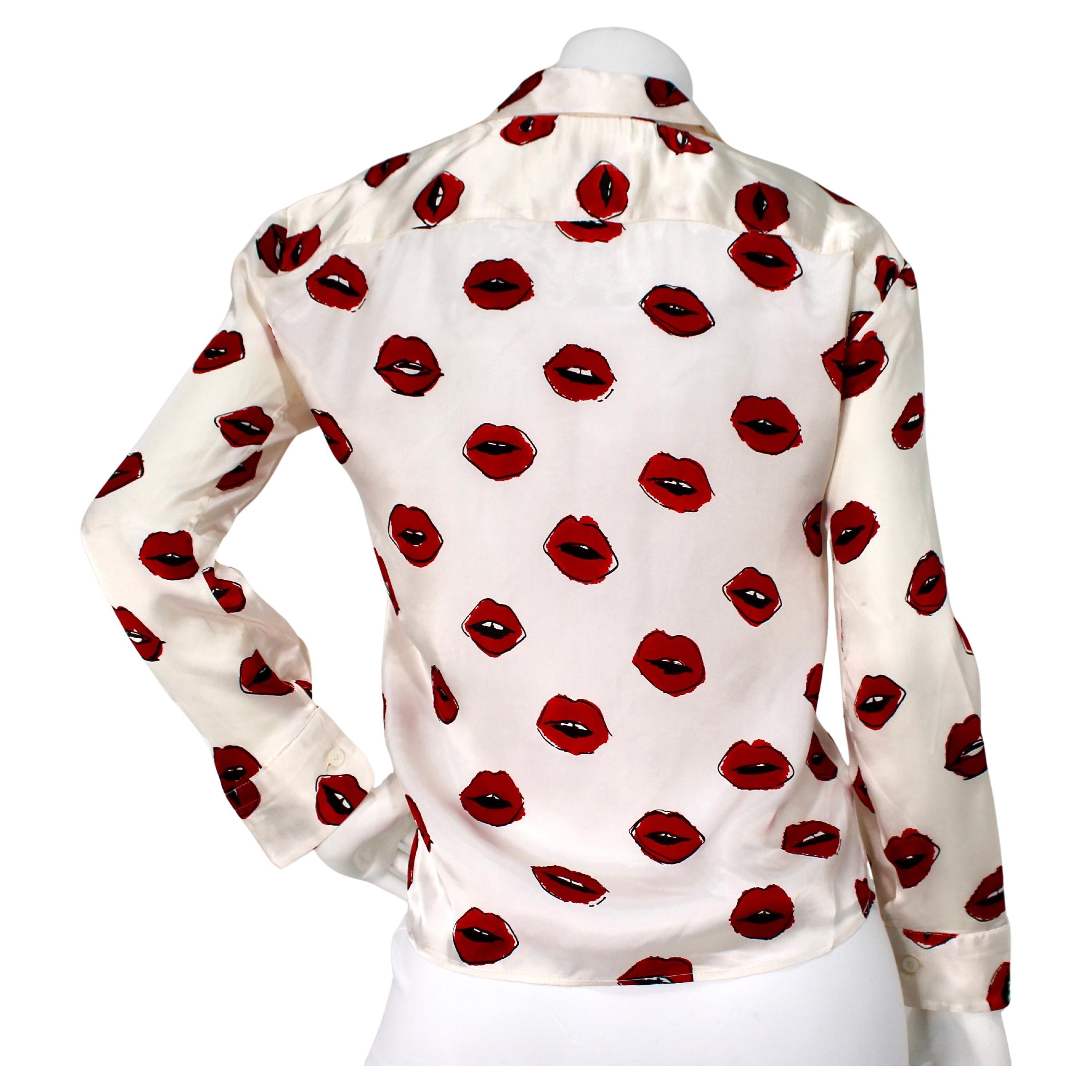 La blusa Khaite Argo Lip Print Silk Twill Button-Up è uno splendido esempio di lusso moderno ed eleganza senza tempo. Realizzata in lussuoso twill di seta, la blusa presenta un'accattivante stampa a labbra che aggiunge un tocco giocoso ma