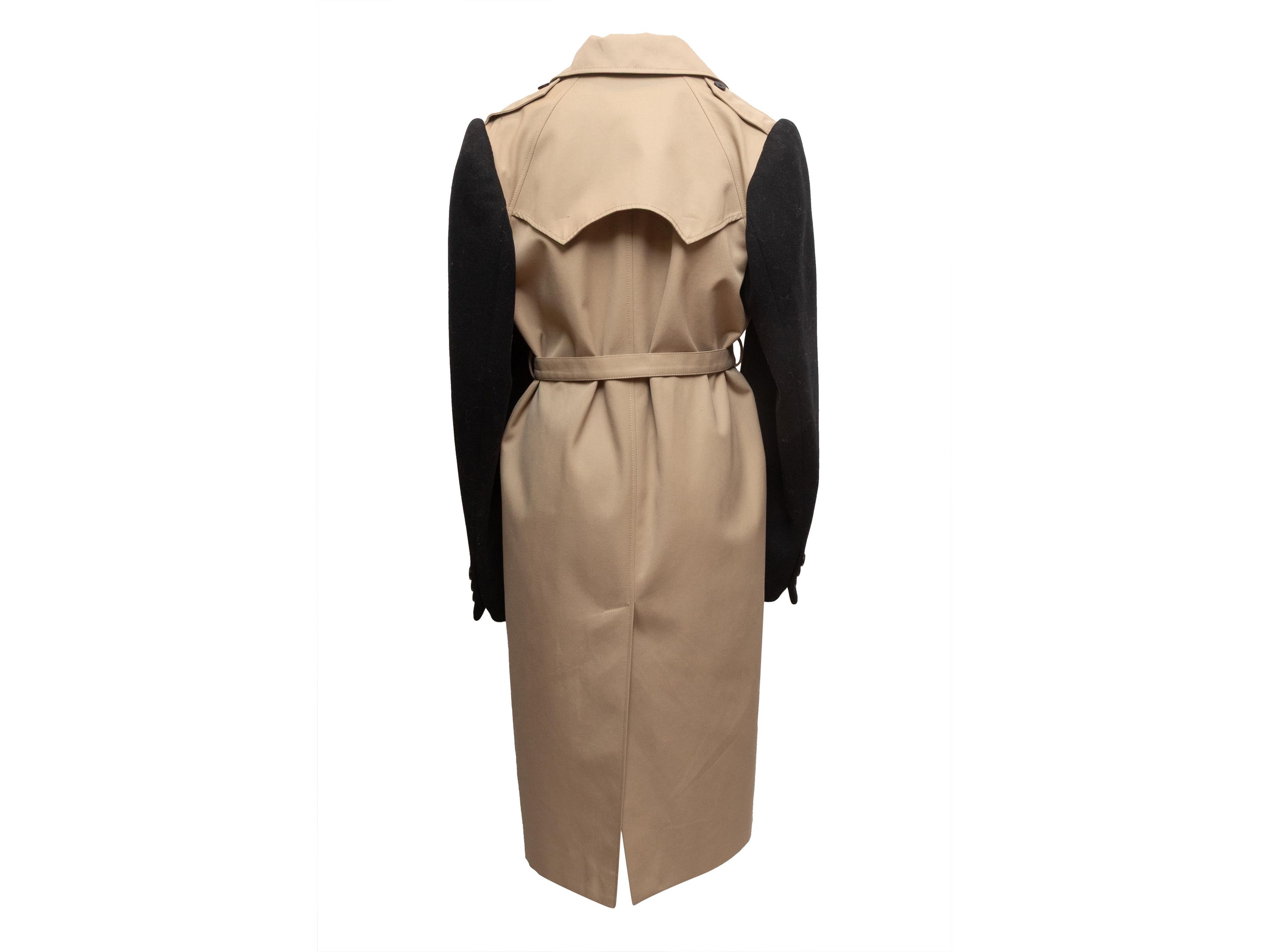 Khaki and black color block long trench coat by Maison Margiela. Notched lapel. Wool sleeves. Belt at waist. Dual hip pockets. Button closures at front. 40