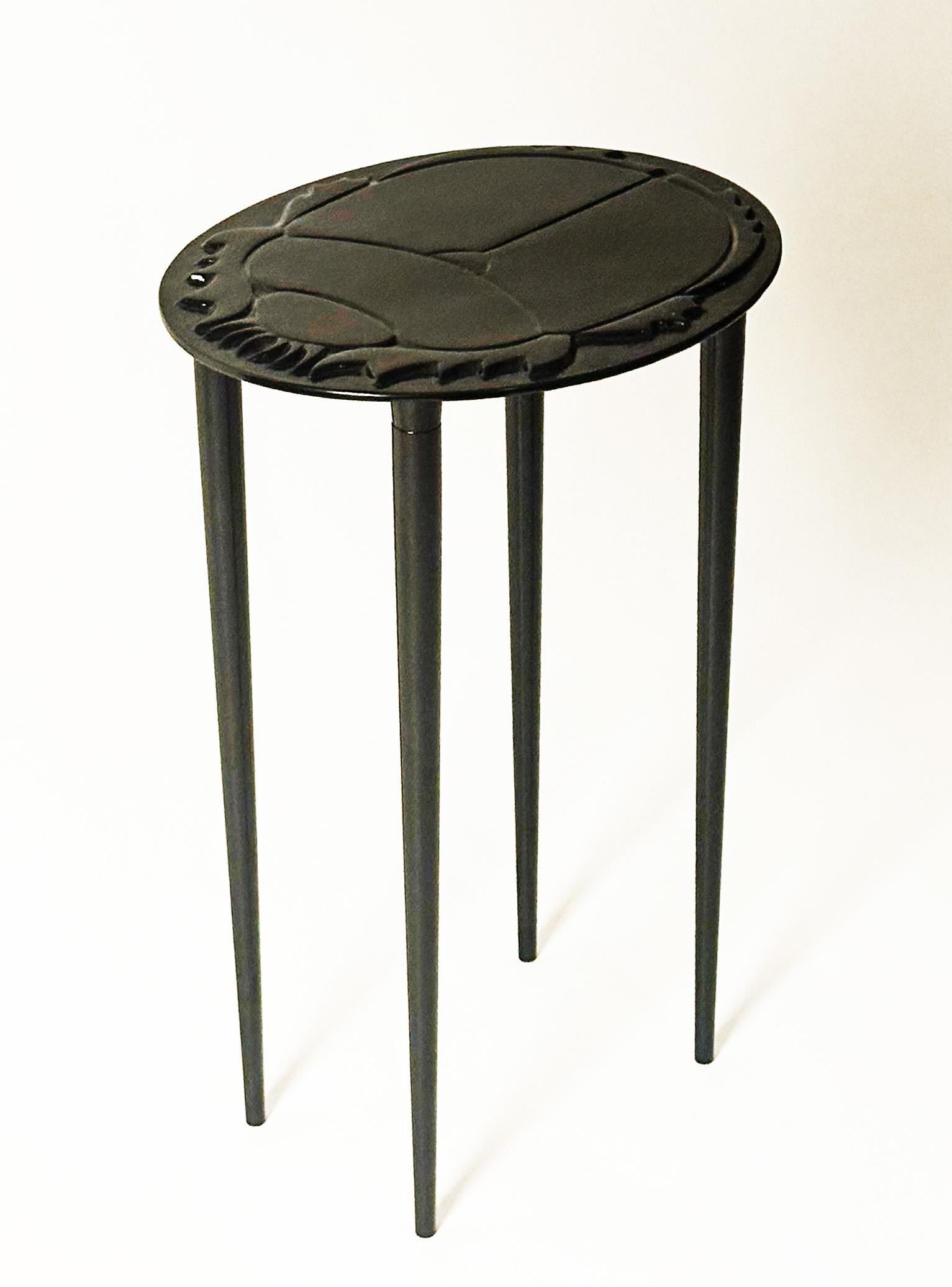Nuestra mesa auxiliar Kheper tiene un sobre de aluminio fundido en bajorrelieve que representa la imagen del antiguo escarabajo egipcio, símbolo de vida y renacimiento. 

La parte superior puede encargarse en aluminio pulido o en pátina de bronce.
