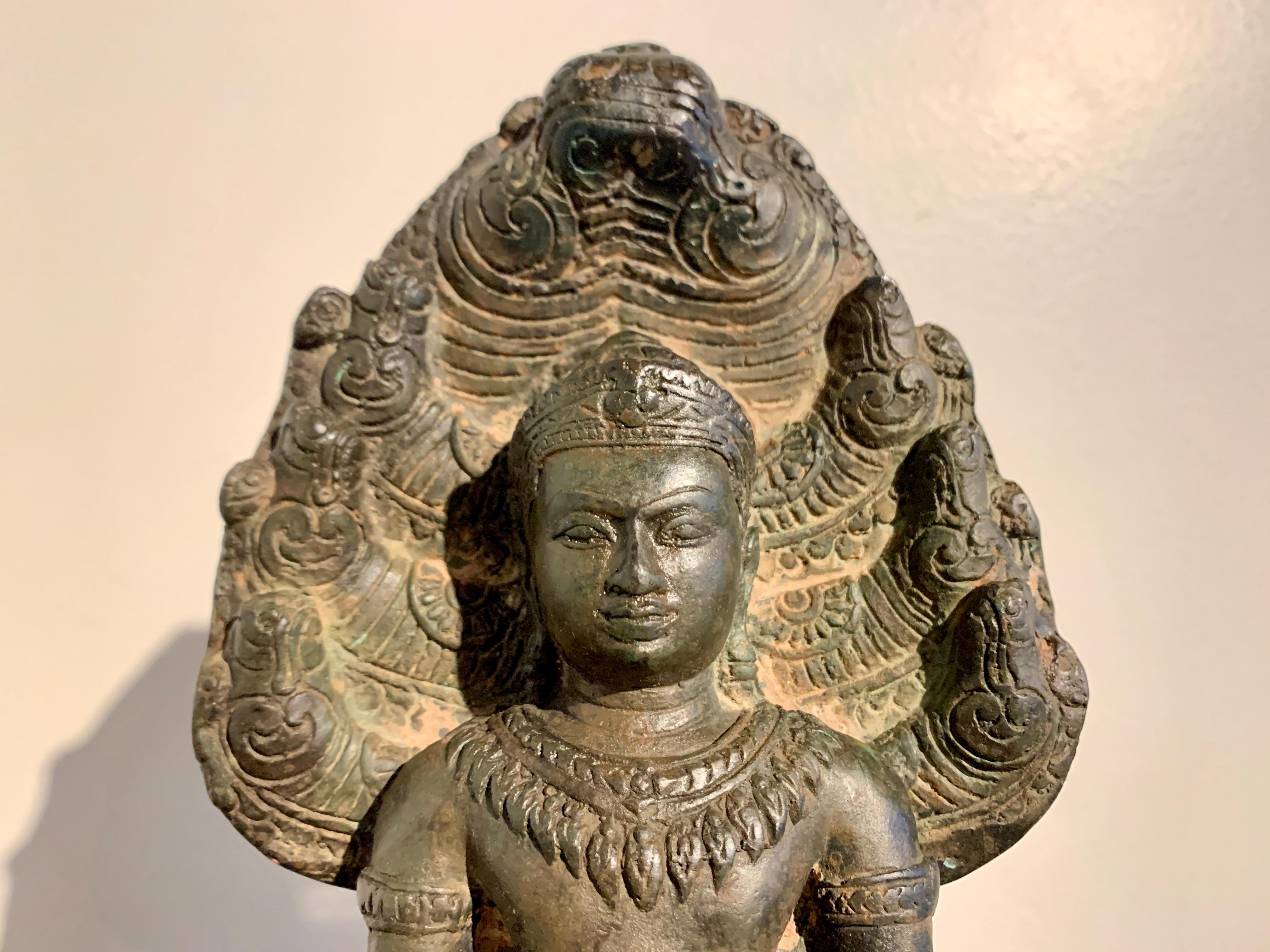 A well cast Khmer style bronze figure of an adorned Buddha sheltered by a Naga, Buddha Muchalinda, 19th century or earlier, Cambodia.

The sculpture in the Khmer style and following the conventional form known as Buddha Muchalinda, with the Buddha