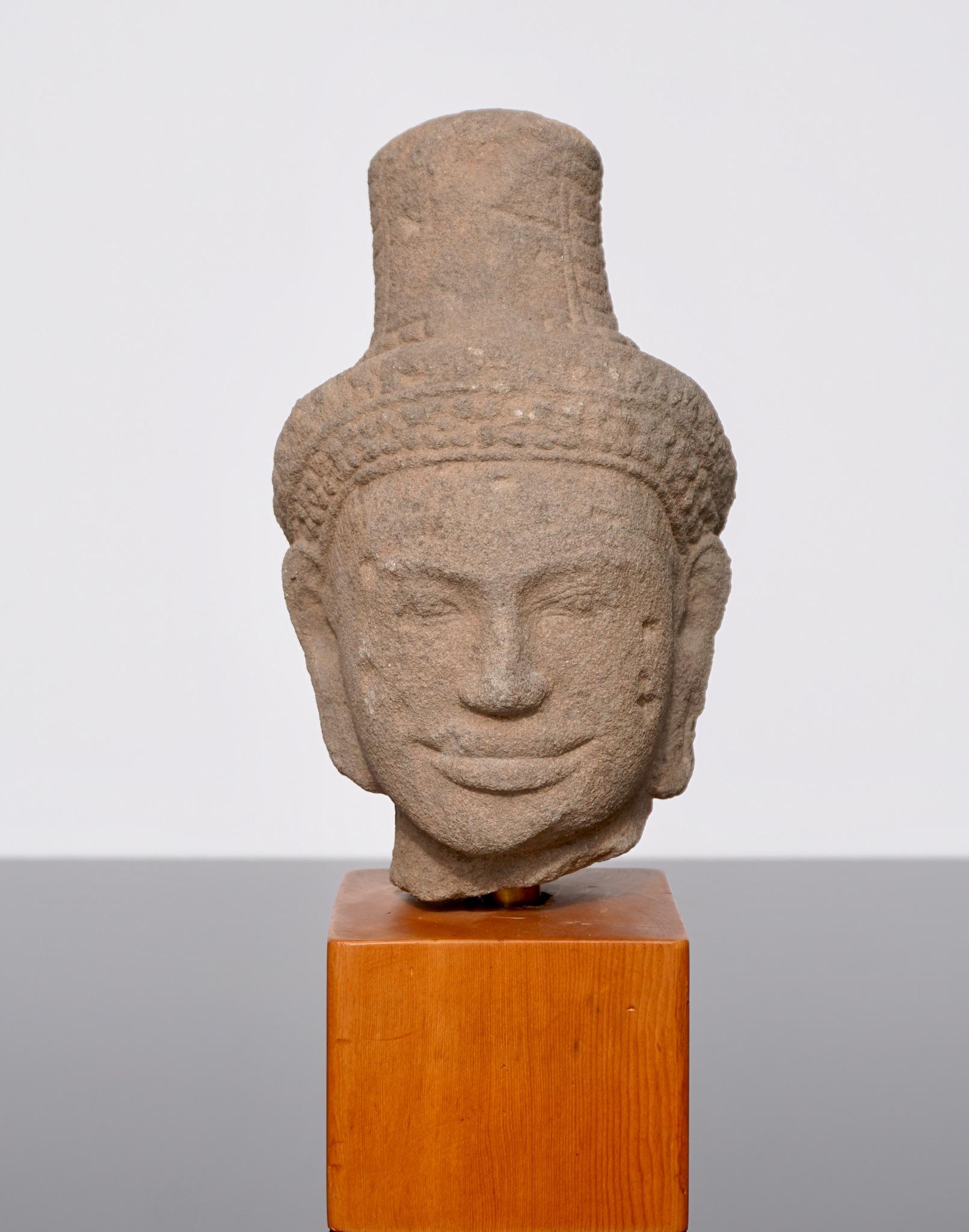 A sandstone figure head of Shiva Khmer, Baphuon style, circa 11th century. A rare Khmer gray sandstone head of Shiva. The handsome head of the divinity deity Shiva. His face with serene expression, almond-shaped eyes, ridged eyebrows and elongated