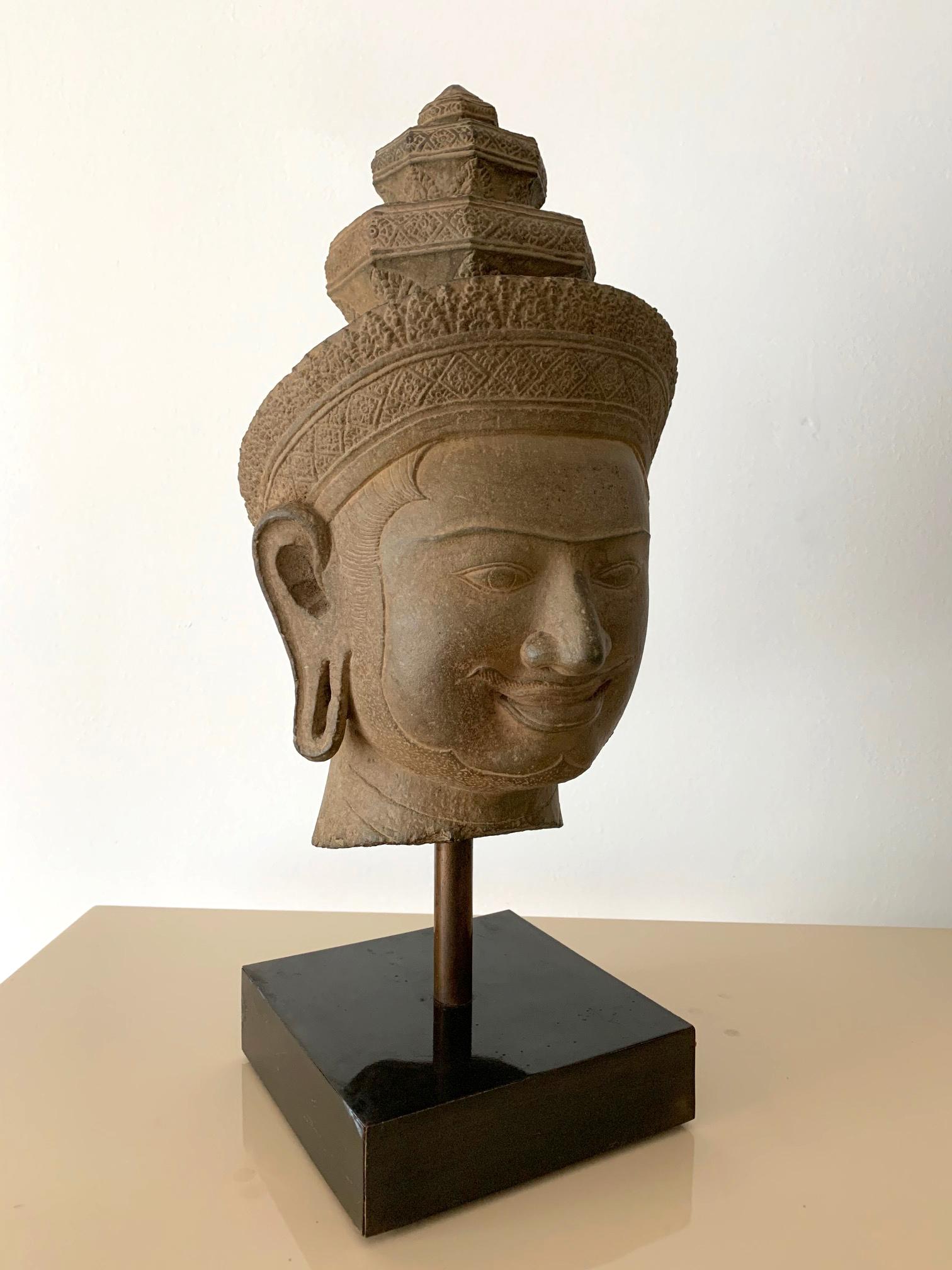 A finely carved sandstone head of Vishnu from Khmer Kingdom (now Cambodia) in Preah Koh style, circa late 9th century. The Hindu god was depicted with a gentle facial expression of serenity. His widely set eyes of almond shape and slightly upturn