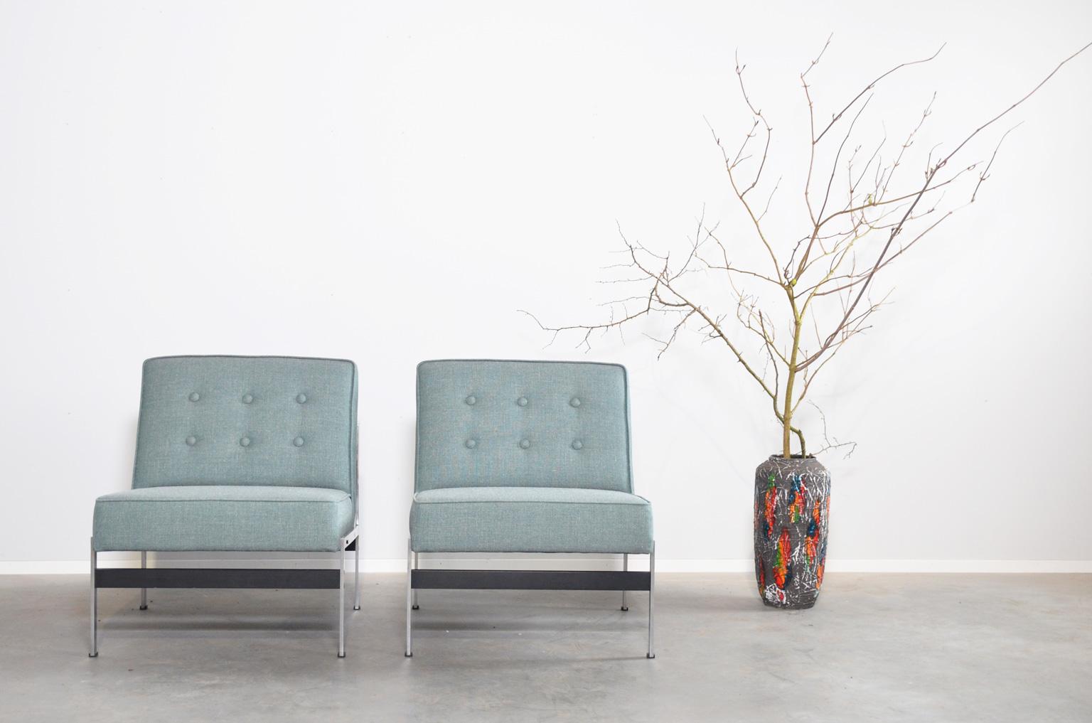 Midcentury armchairs from the 020 series by Dutch designer Kho Liang Ie for Artifort. The design of the chairs is simple and the construction of metal and wood is clearly visible. Both chairs have new seating’s and have a new green/blue upholstery