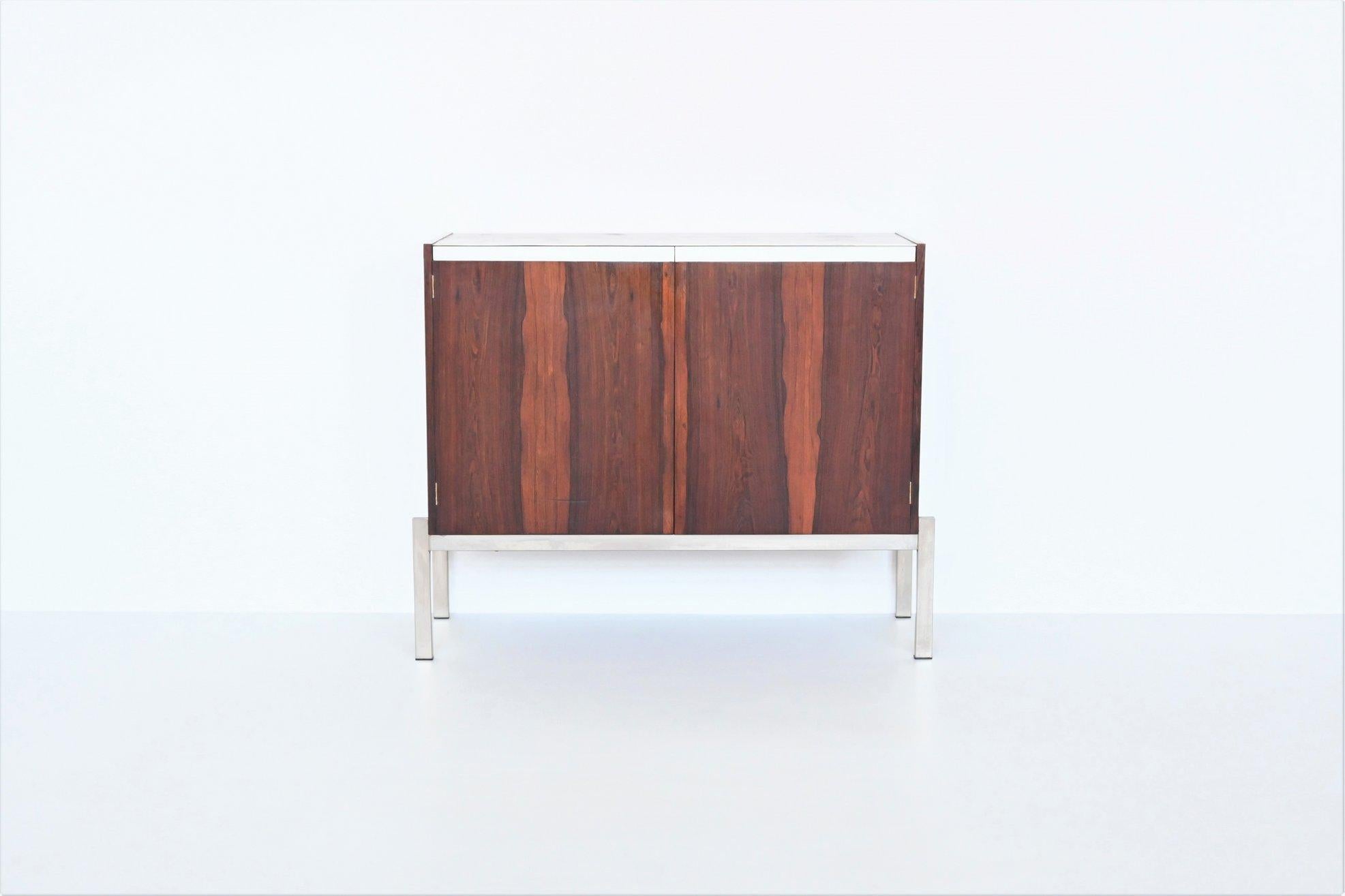 Beautiful shaped modernist small cabinet designed by Kho Liang Ie and Wim Crouwel and manufactured by Fristho Franeker, The Netherlands 1957. This fantastic symmetric cabinet is executed in nicely grained rosewood supported by a chrome plated metal