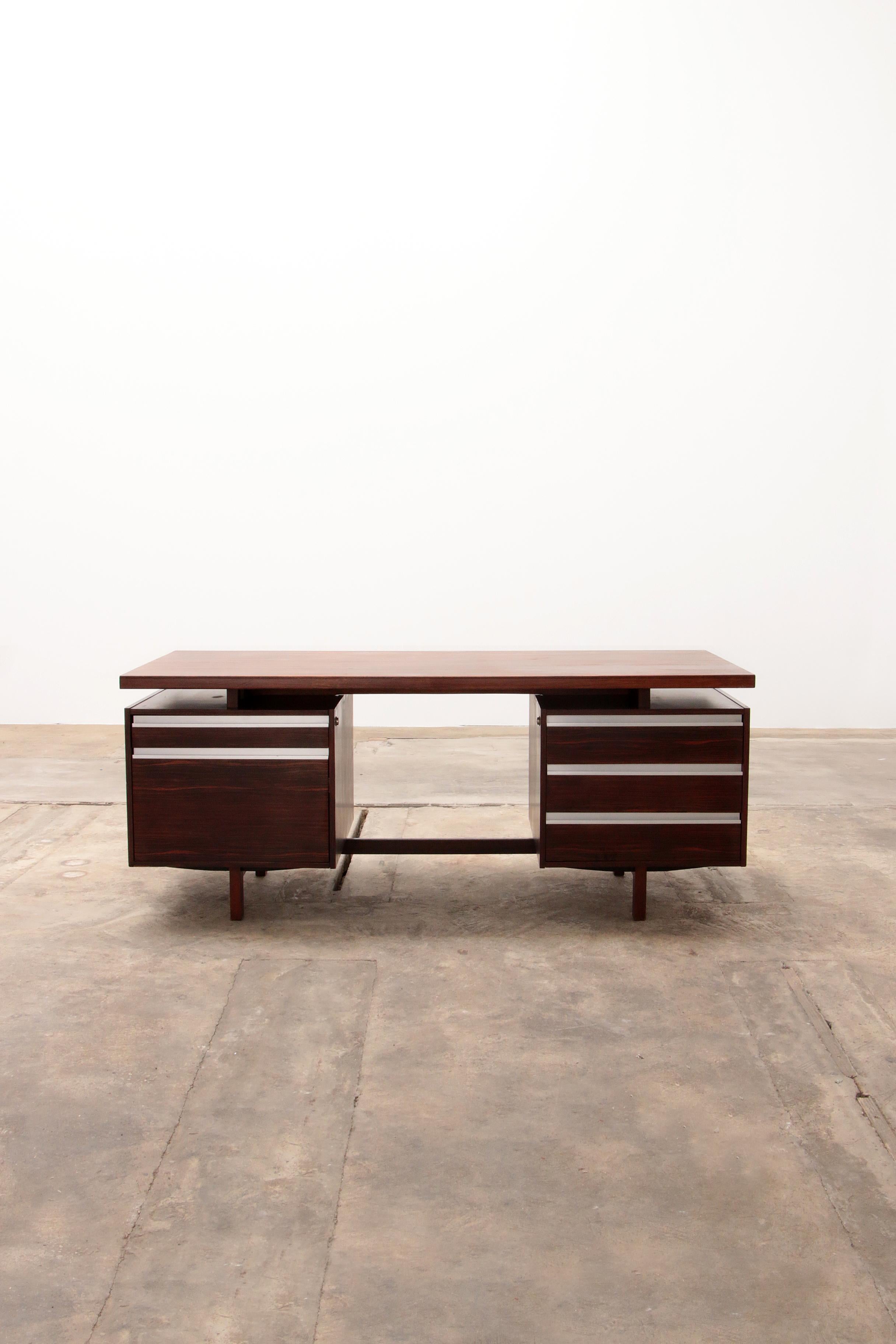 Seltener Chefschreibtisch Modell J1, entworfen von Kho Liang Ie für Fristho im Jahr 1956.

Executive-Schreibtisch aus Holz und mit Massivholz zwischen der Platte und den Beinen fertig, die Griffe sind aus Aluminium.

Der Schreibtisch hat an der