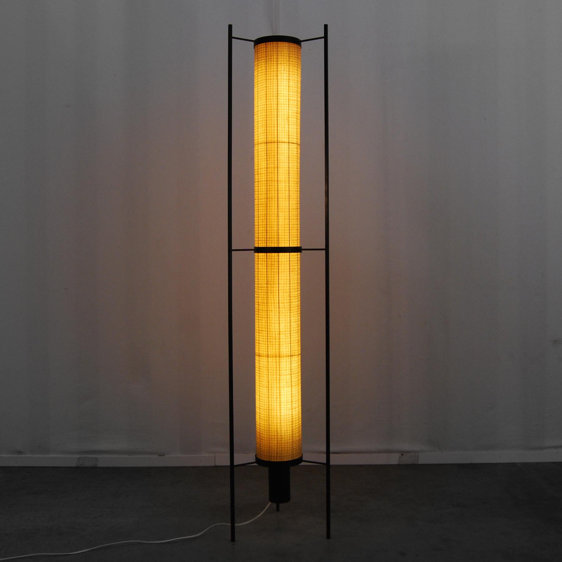 Minimalist (Japanese inspired) design floor lamp contains a semi-transparent glass fiber cylinder attached to a black metal frame. The floor lamp produces a warm diffused light. All parts are in very good vintage condition with only light wear.