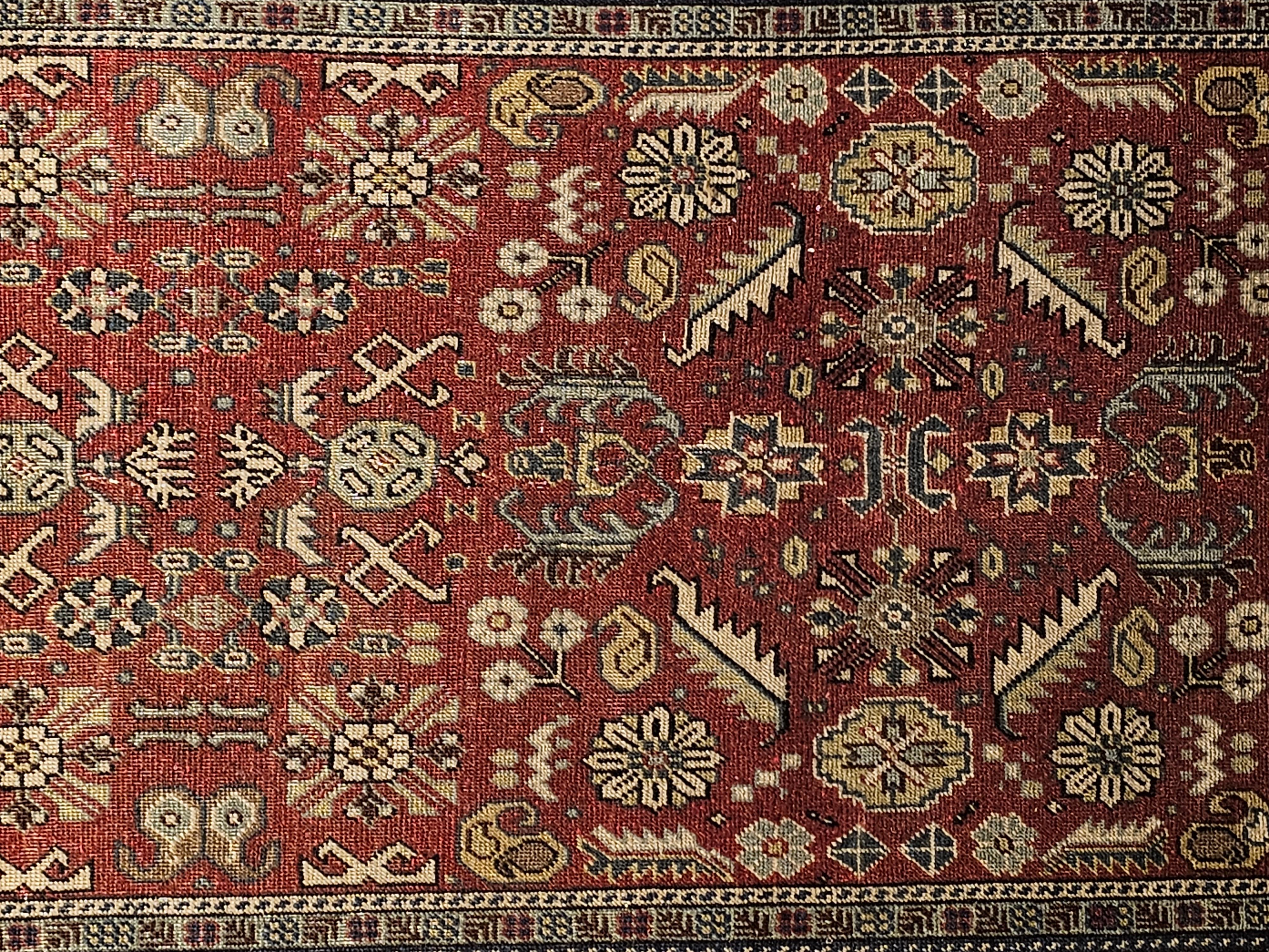 Vintage Khotan Teppich mit geometrischem Muster in den Farben Ziegelrot, Gelb und Elfenbein.  Der Khotan-Teppich wurde von Hand gewebt und stammt aus Zentralasien, etwa aus dem ersten Viertel des 19. Jahrhunderts.  Der Teppich hat ein Allover-Muster