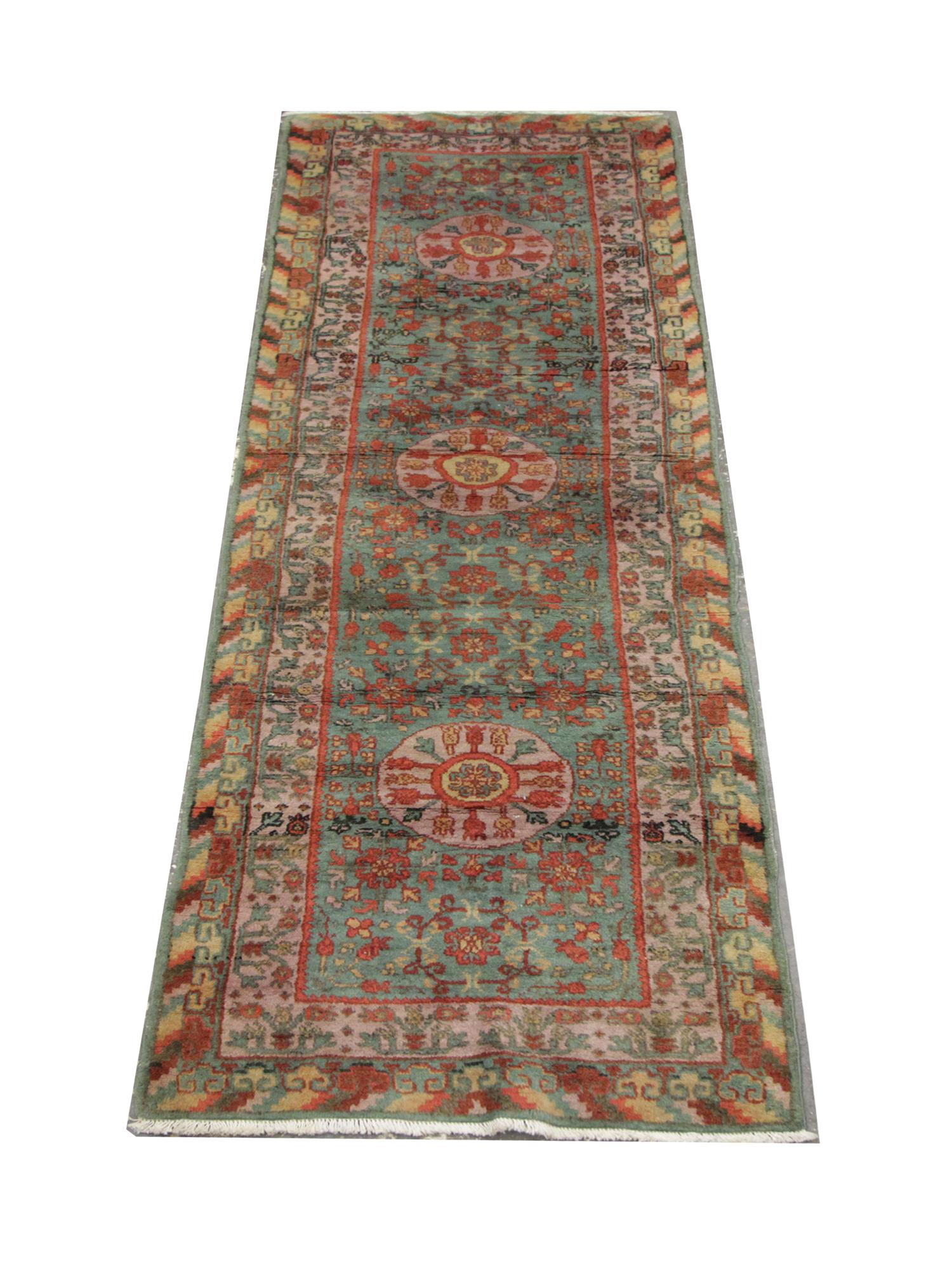 With vibrant green pink red and yellow tones, this beautiful runner rug features three circular motifs through the center on a highly-detailed green background, drenched in symmetrical rose motifs. This is then pulled together with stunning