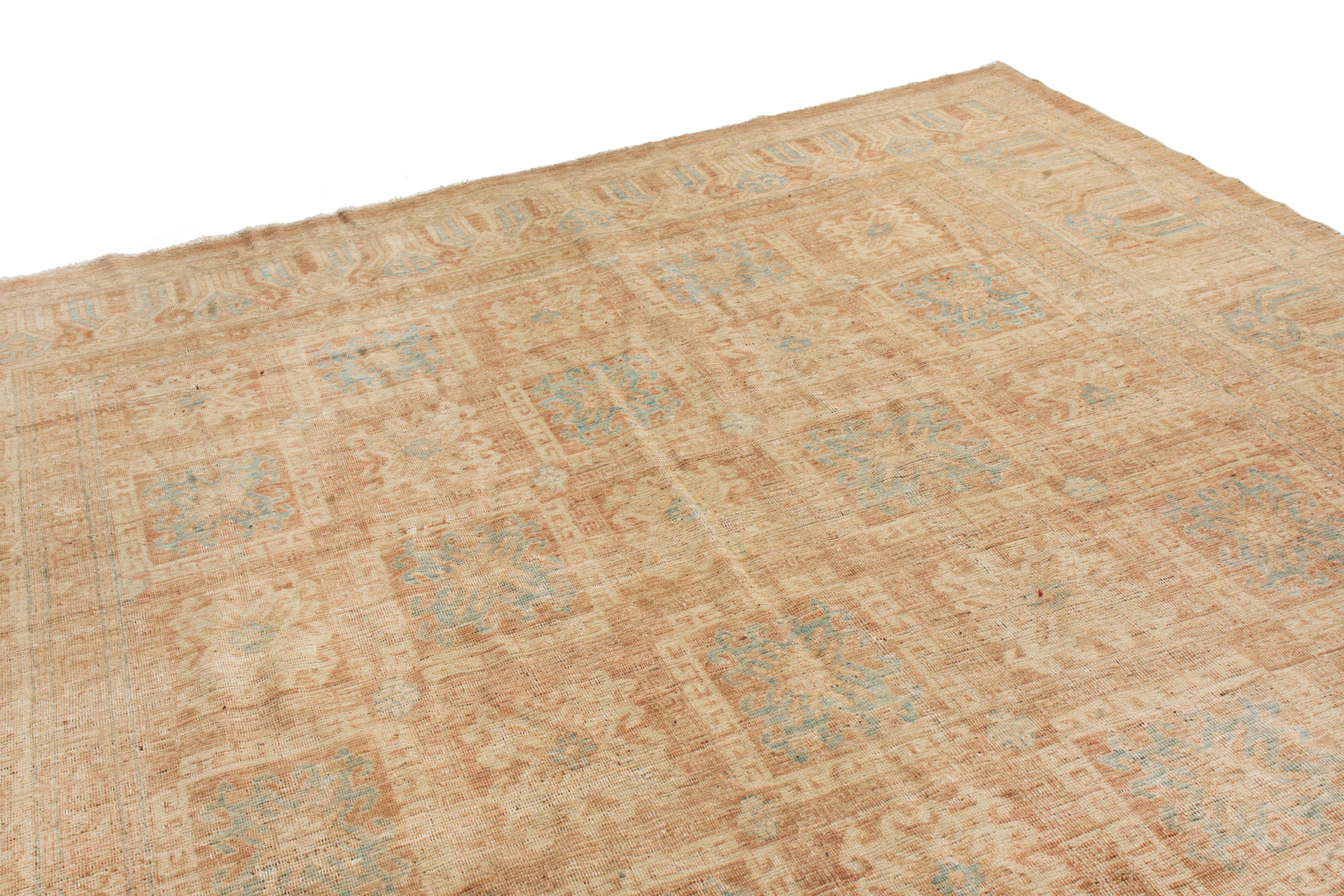 Hand knotted in high-quality wool originating from East Turkestan, this Khotan rug enjoys a rare variant of the classical cloudband border inspired frolic antique and vintage pieces complementing the simple elegance of its sky blue and beige