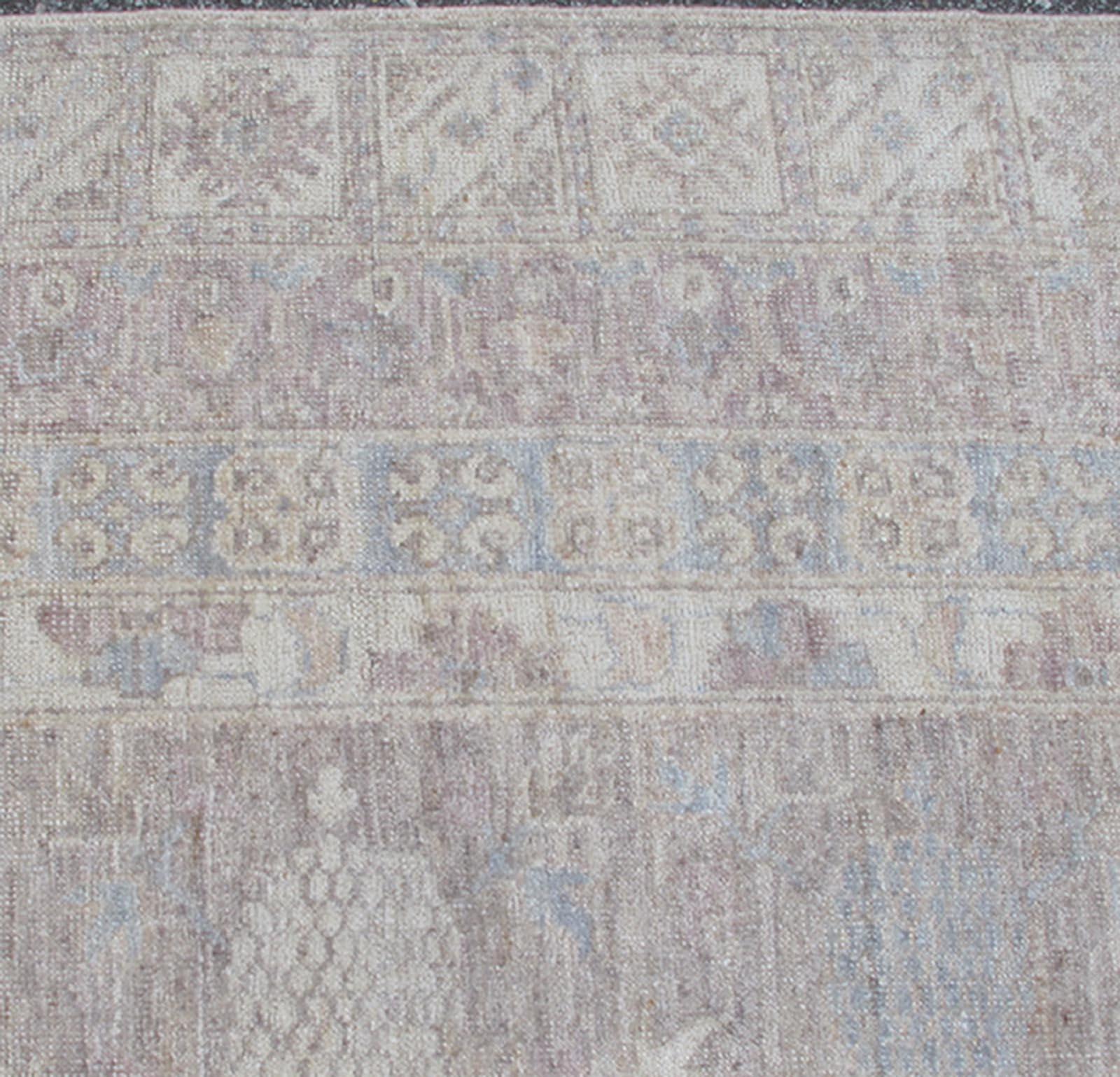 This Khotan features an all-over design flanked by a repeating pattern in the border. The entirety of the piece is rendered in light tones, which makes it a versatile rug, well-suited for a variety of interiors. Colors include light blue, cream and