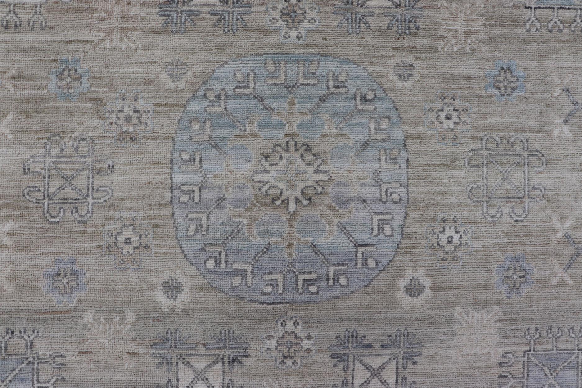 Measures: 6'0 x 9'1 
Khotan Design Rug with Circular Medallion in Light Green, Light Blue, and Cream. Keivan Woven Arts, rug/AWR-12172 country of origin / type: Afghanistan / Khotan.
This Khotan features a geometric all-over design flanked by a