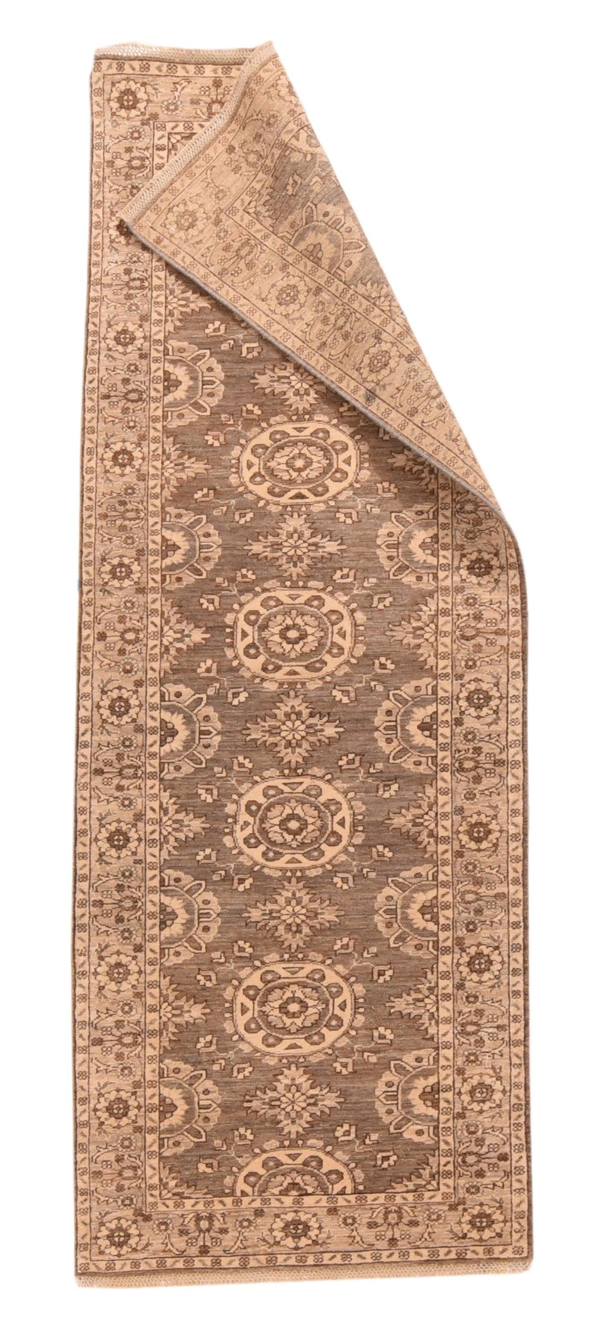 Khotan Teppich 2'10'' x 8'3''. Fünf volle und zwei halbe, leicht abgeflachte, runde Sandmedaillons sind auf dem korallenbraunen, abgewaschenen Feld angebracht, zwischen denen gezackte Kreuze und halbe Medaillons an den Seiten verlaufen. In der