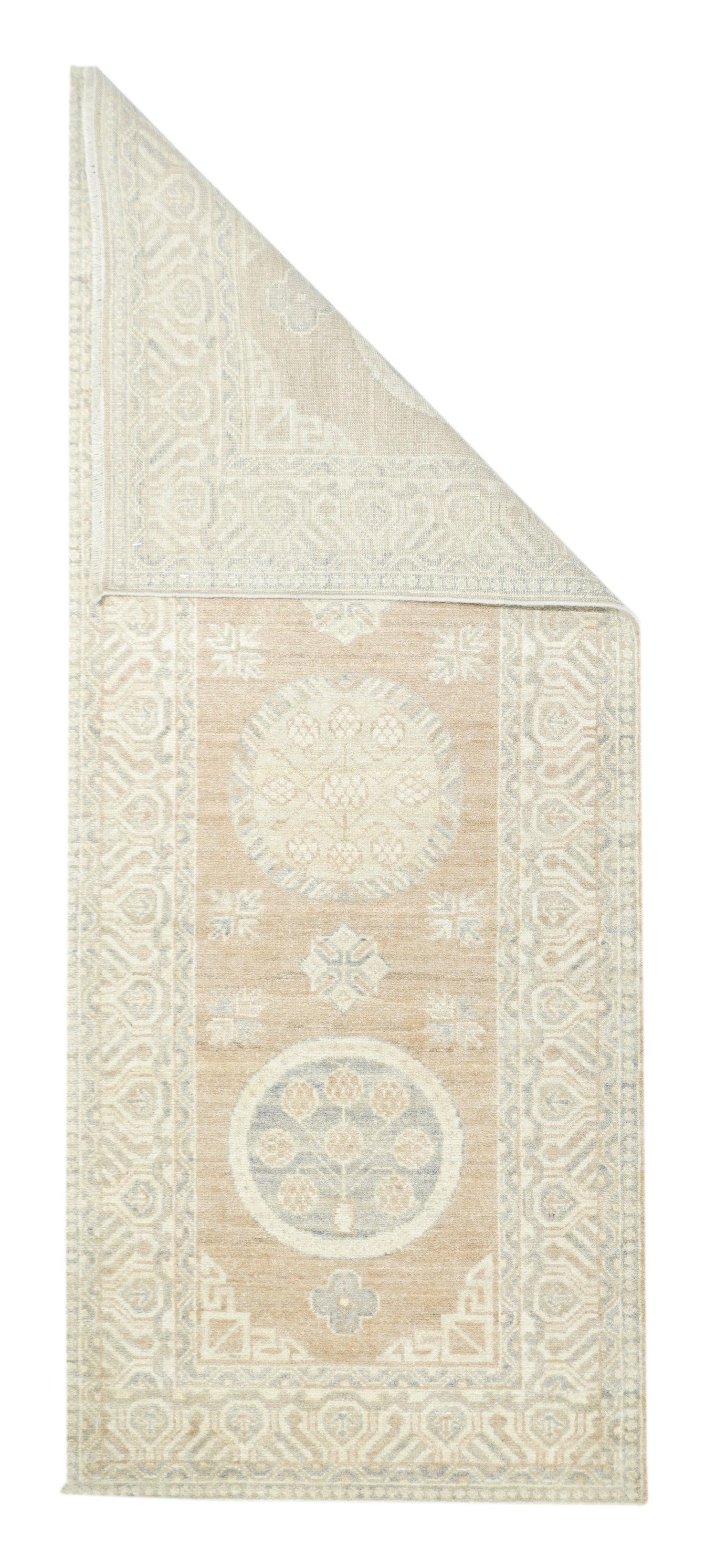 Khotan Rug 2'6'' x 6'3''. In almost the traditional Khotan k'ang carpet 2:1 format, two slate blue pomegranate tree and vase 
