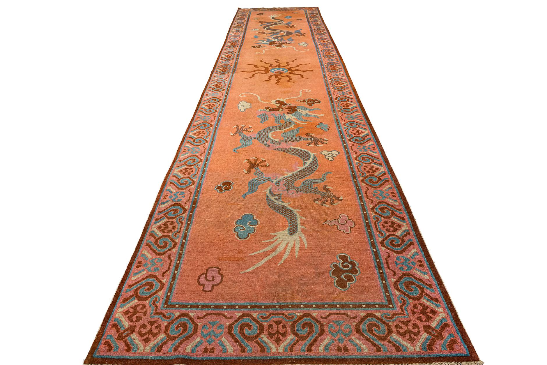 This extraordinary Khotan rug, measuring a majestic 530 × 120 cm, is a timeless piece that weaves together history, artistry, and cultural symbolism into a single, stunning tapestry. Originating from the ancient Silk Road city of Khotan, this rug