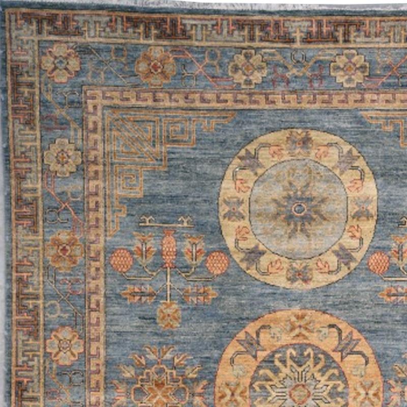 A medium sized rug with traditional Khotan design. The pile is made of high end quality wool - hand spun, hand dyed with all vegetable dyes and knotted by master weavers. The rug is very decorative and has a towards square format. The condition is