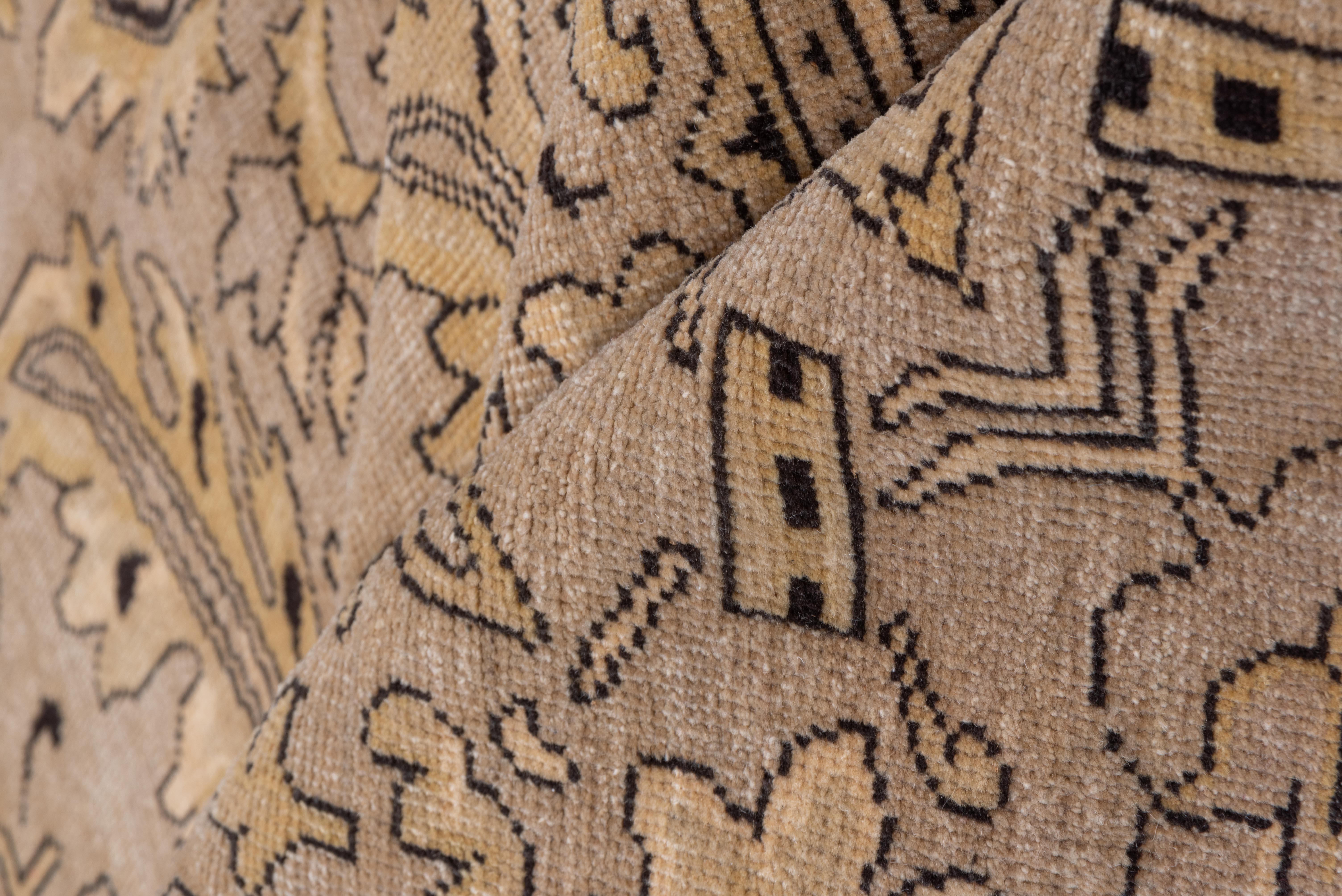 This vintage Khotan rug features an architectural allover composition of stylized pomegranate trees and fluted vases, symmetrically aligned across a taupe field with accents of soft ivory, charcoal, and warm camel. The pattern is both ornamental and