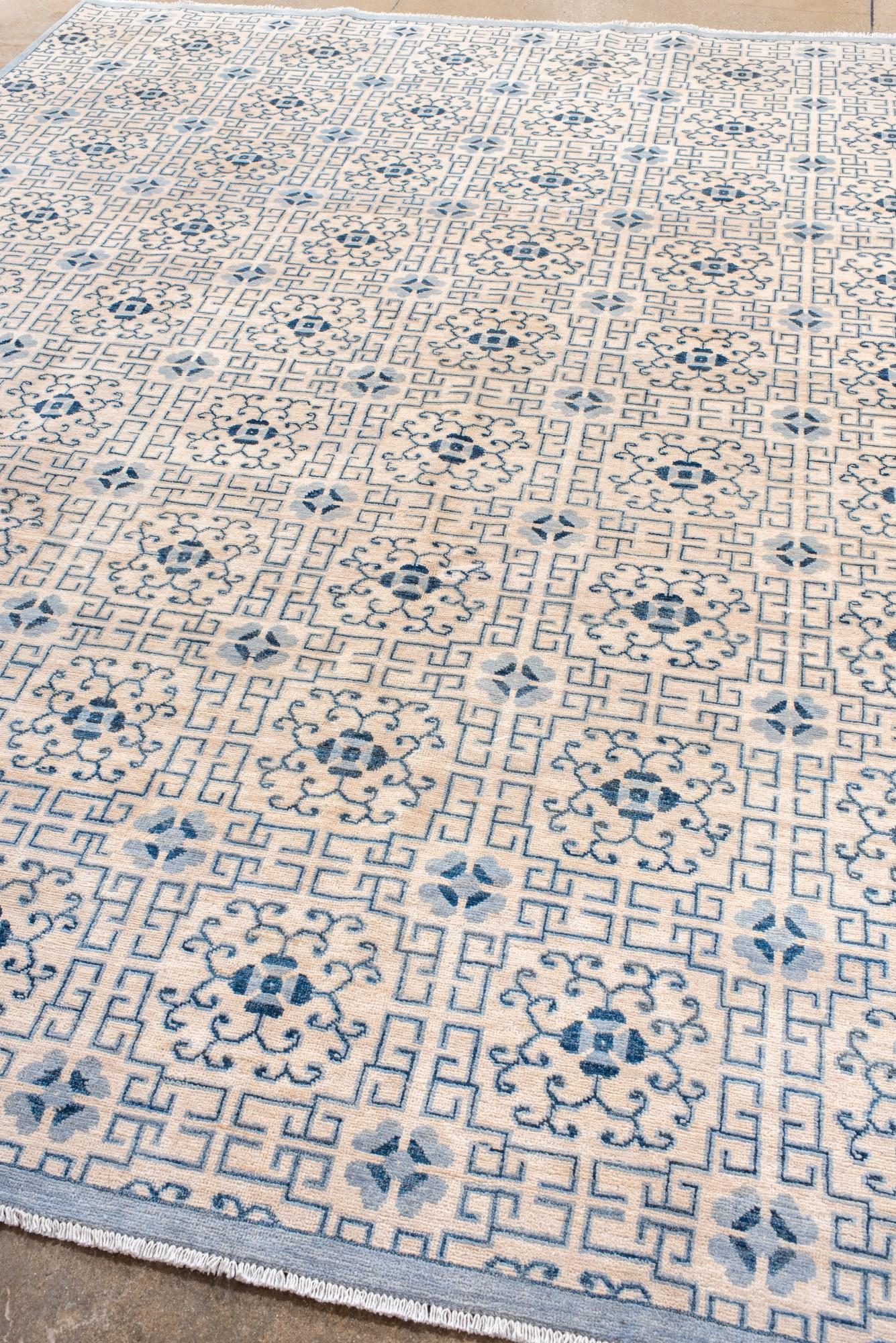 Turkestan Tappeto Khotan con disegni a melograno e a reticolo ripetuti in blu e avorio. in vendita